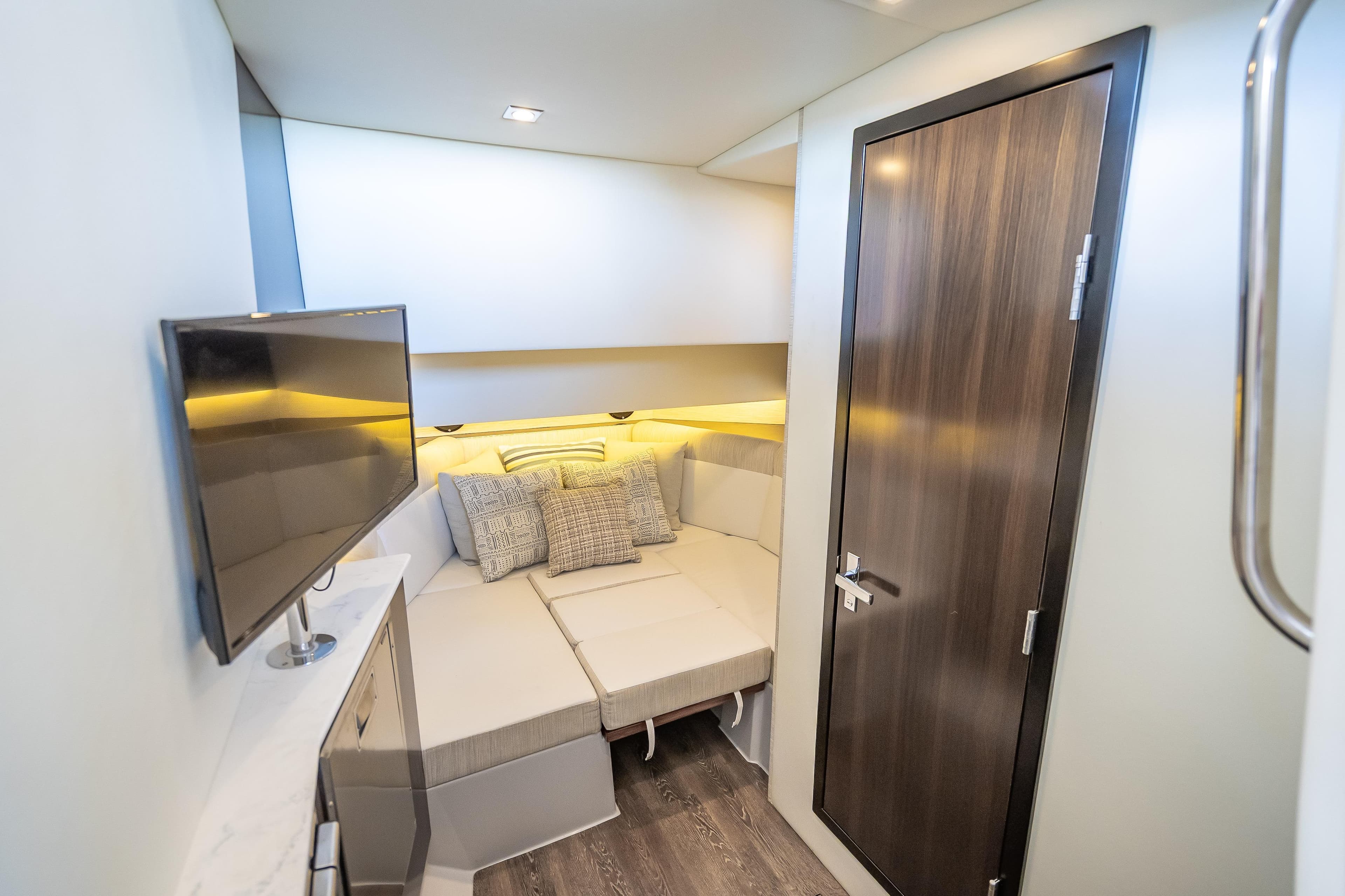 Luxurious interior cabin of 2022 Cruisers Yachts 38 GLS OB with TV and cozy bed.