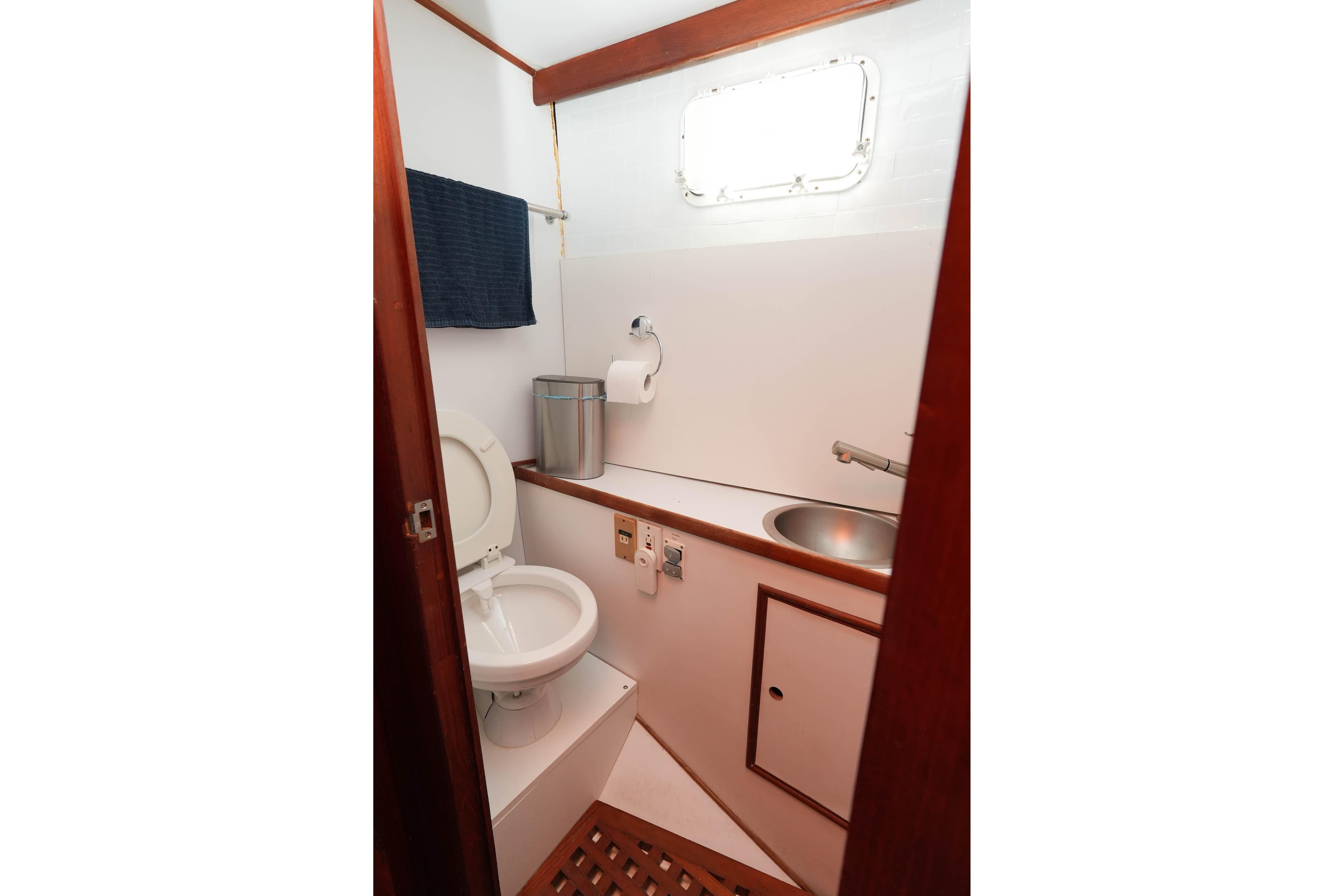 1982 CHB Classic Trawler 41 bathroom with toilet, sink, and wooden accents.