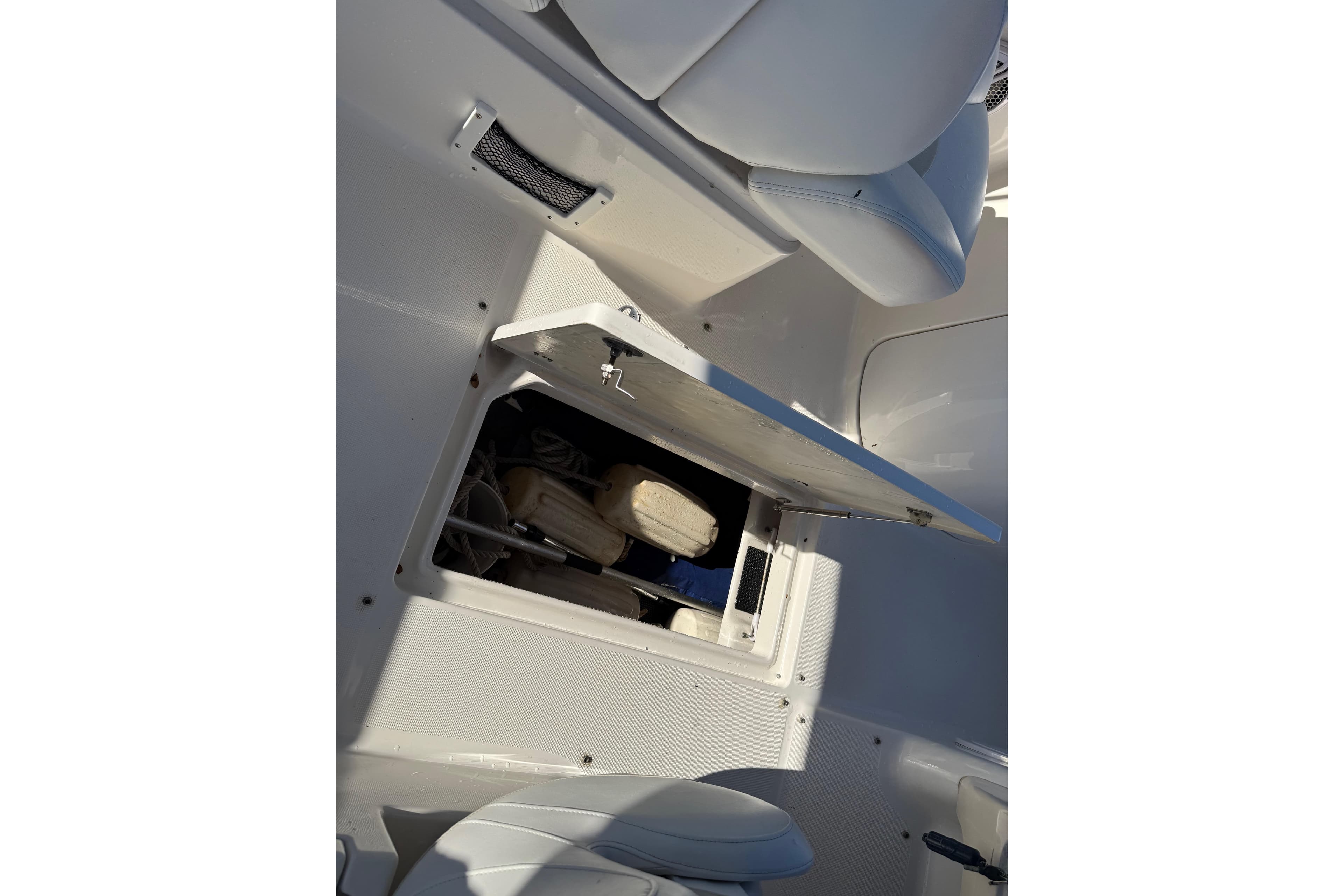 Storage compartment on a 2015 Robalo R227 Dual Console boat, open with visible contents.