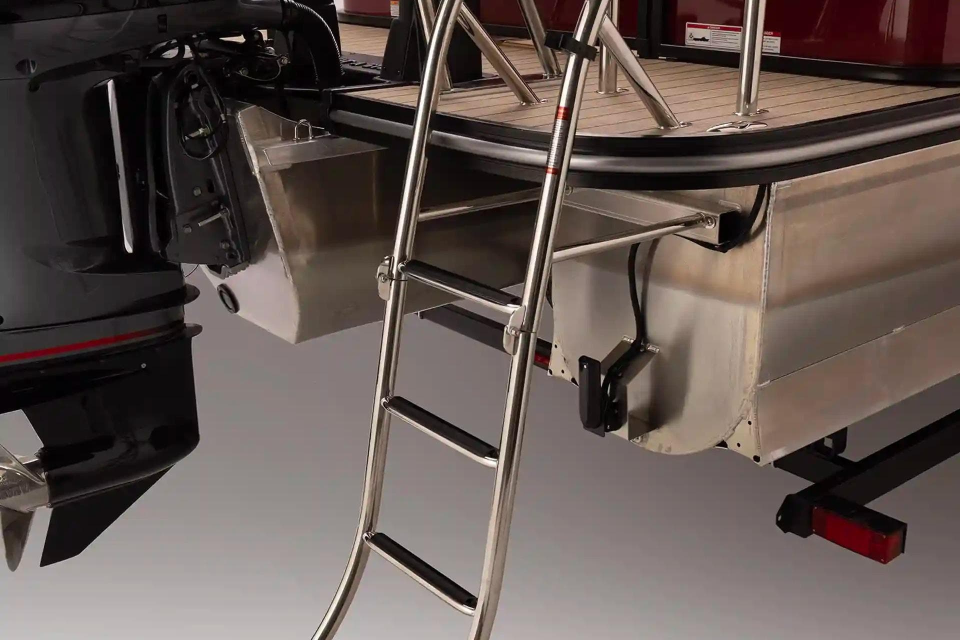 Rear view of 2026 SunCatcher Elite 322 SR boat with ladder and motor.