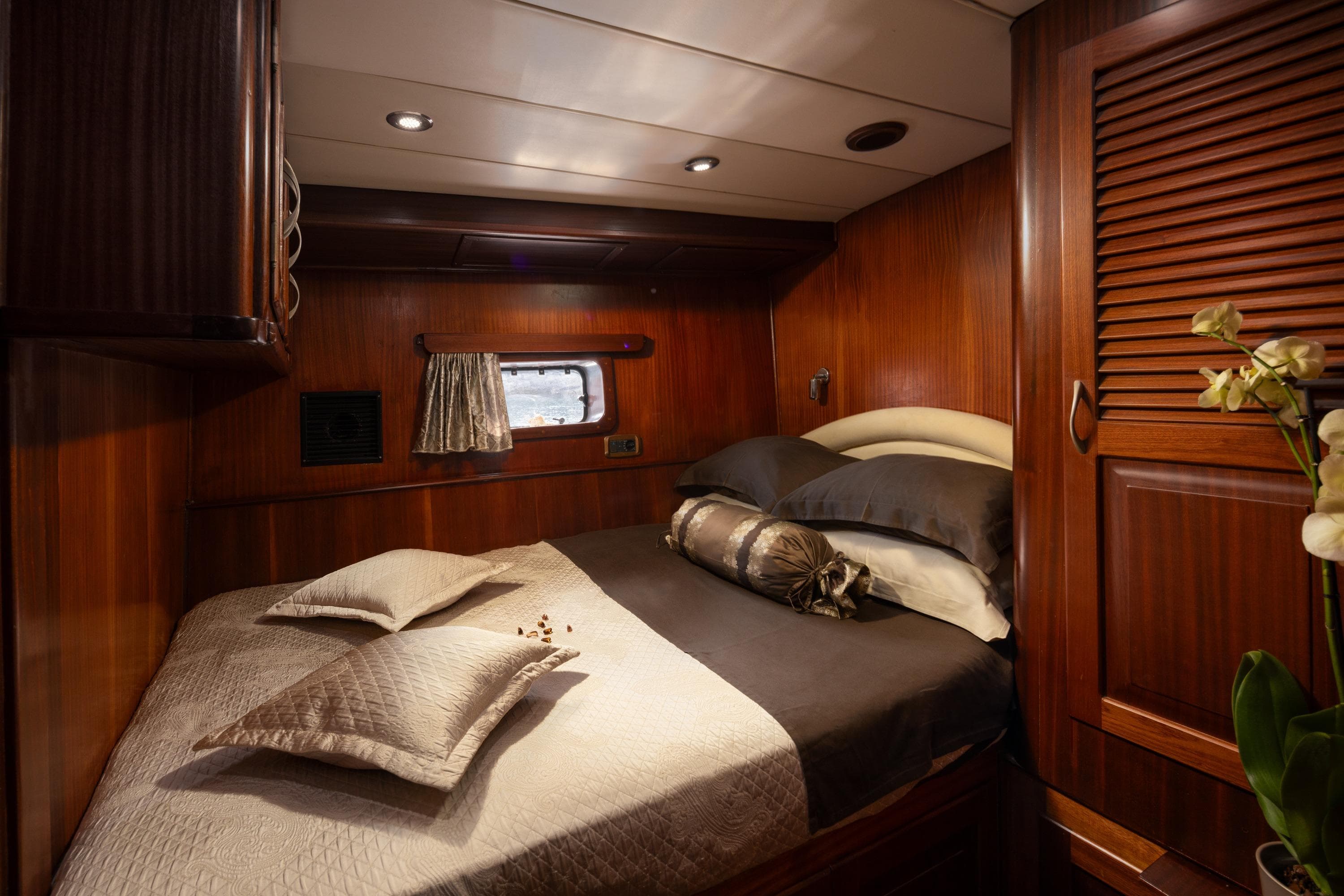 Luxurious wooden cabin interior on a 2000 Custom GULET yacht with cozy bedding.