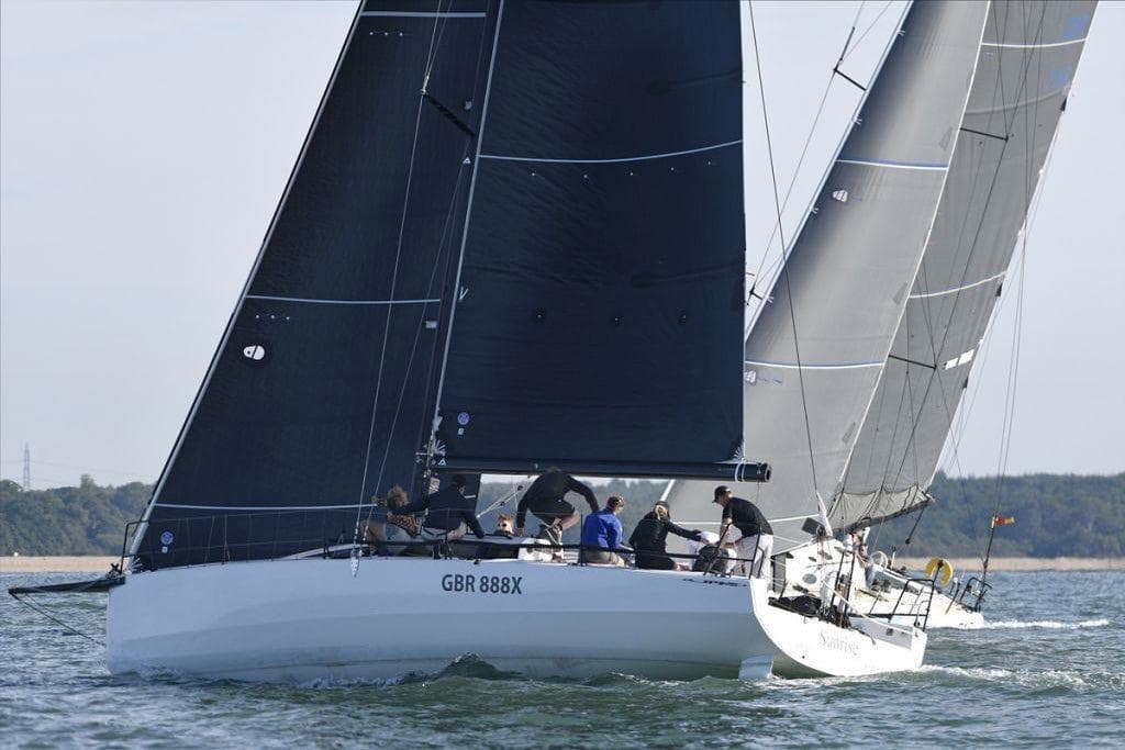 Sailing race featuring 2018 JPK 1180 boats with black sails on open water.