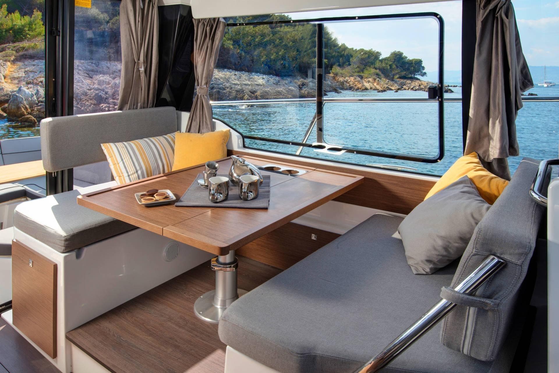 Interior of 2026 Jeanneau NC 1095 Coupe with cozy seating and scenic ocean view.