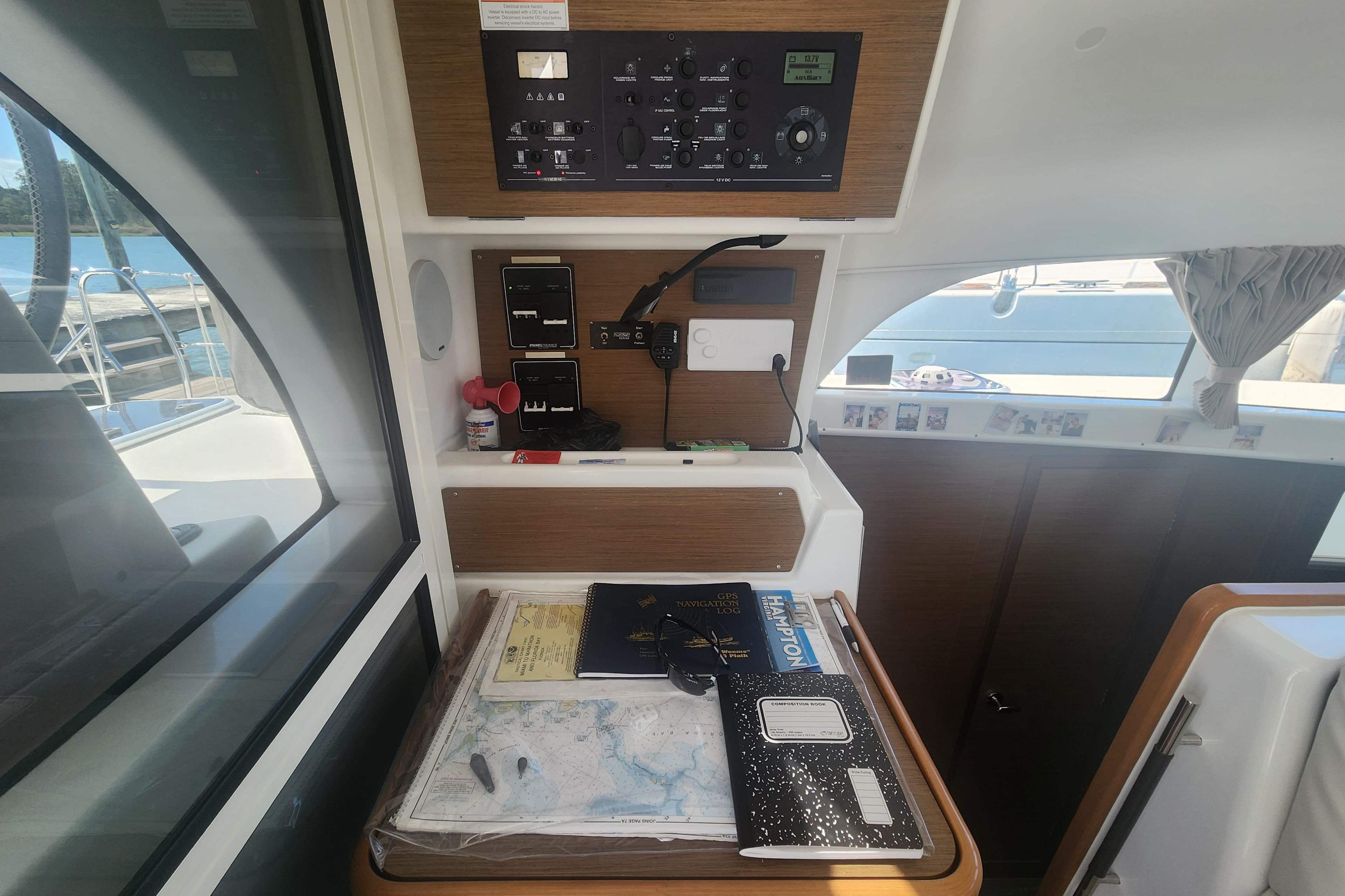 Navigation station inside a 2019 Lagoon 380 catamaran with charts and control panel.