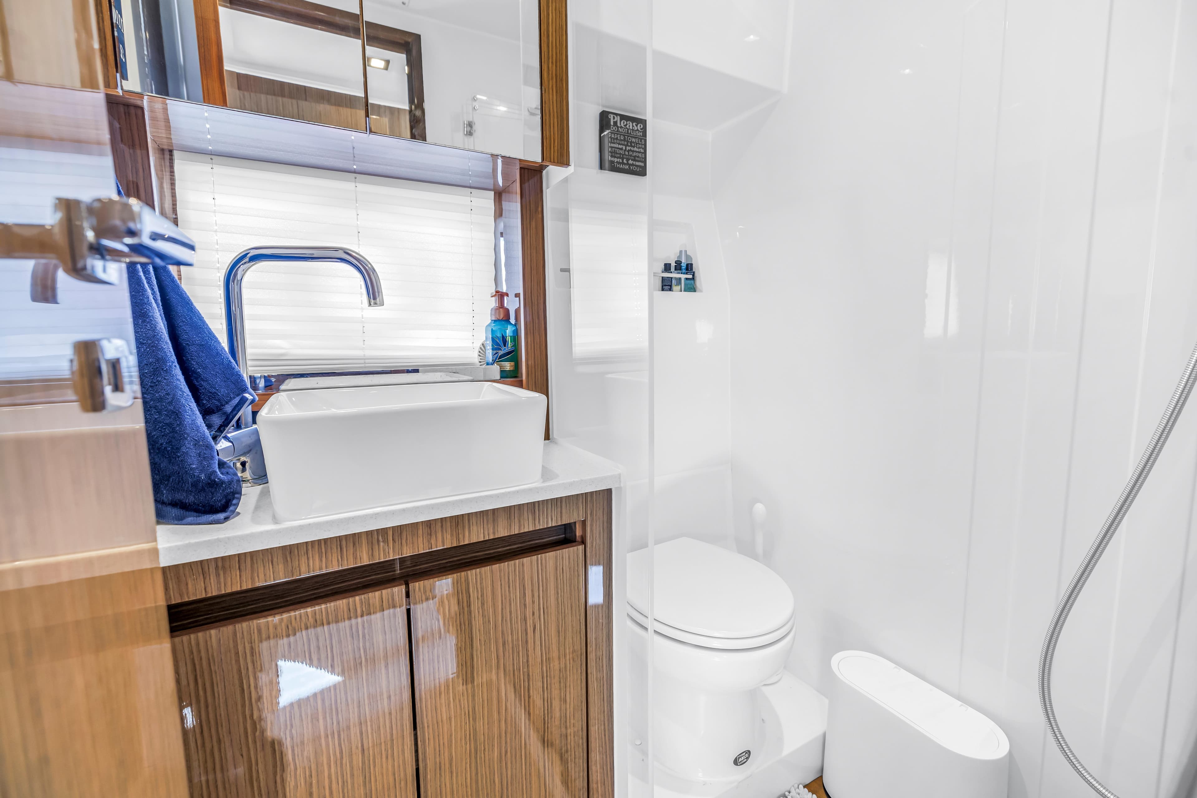 Modern bathroom in 2020 Sealine C390 yacht with sleek fixtures and wooden cabinetry.