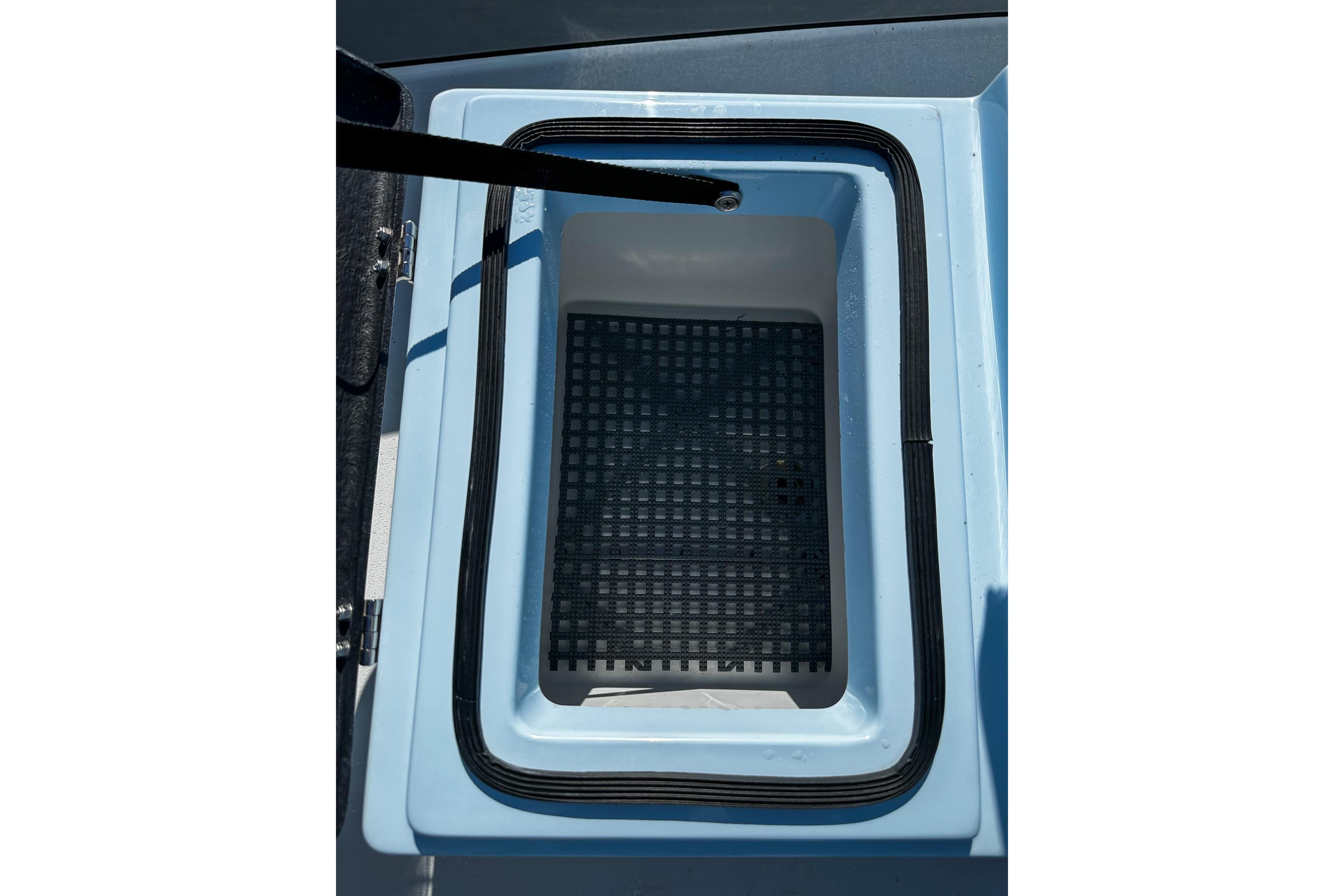 2020 East Cape Evo V boat storage compartment with black grid mat.