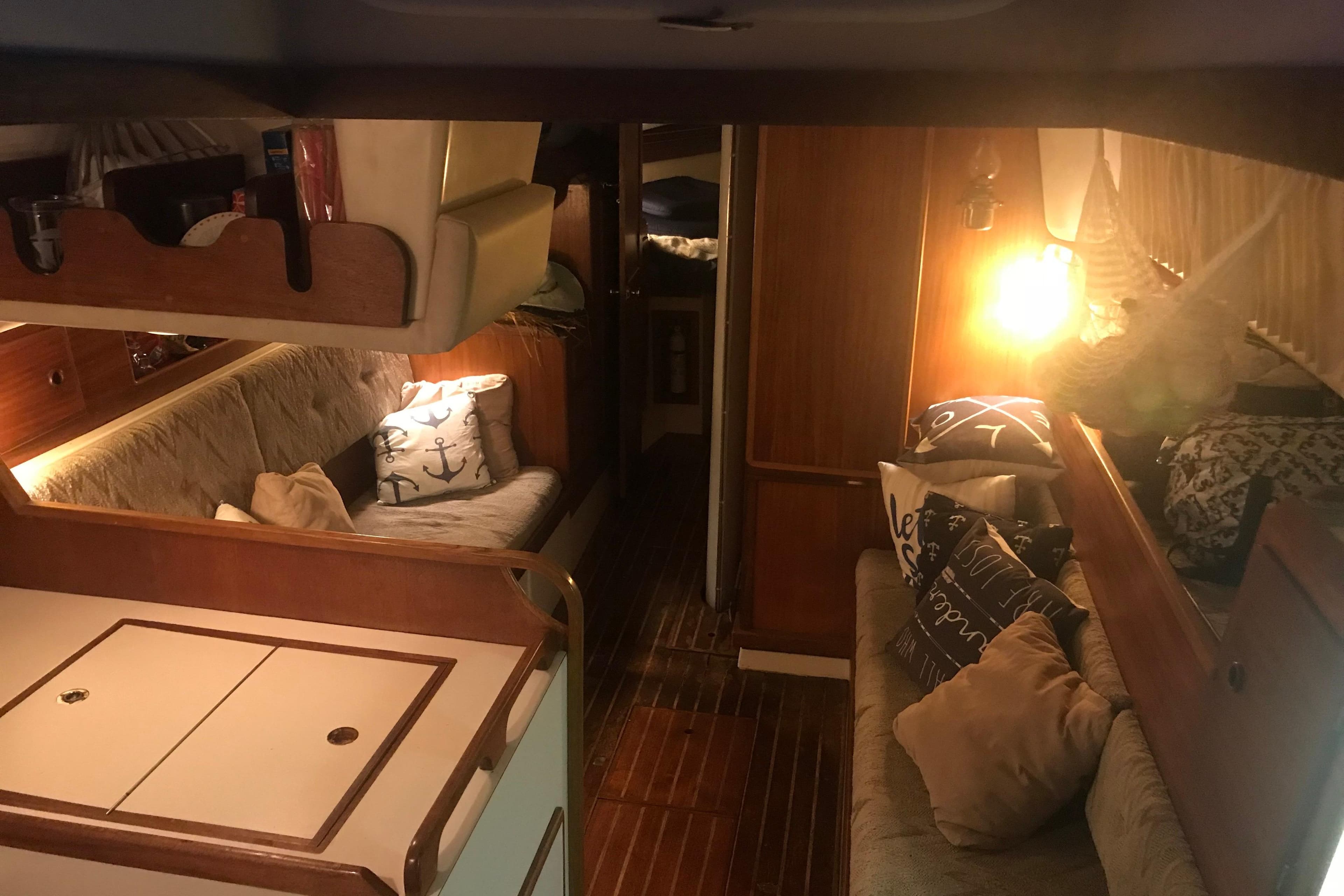 Cozy interior of a 1980 Pearson 365 Sloop with wooden furnishings and nautical decor.