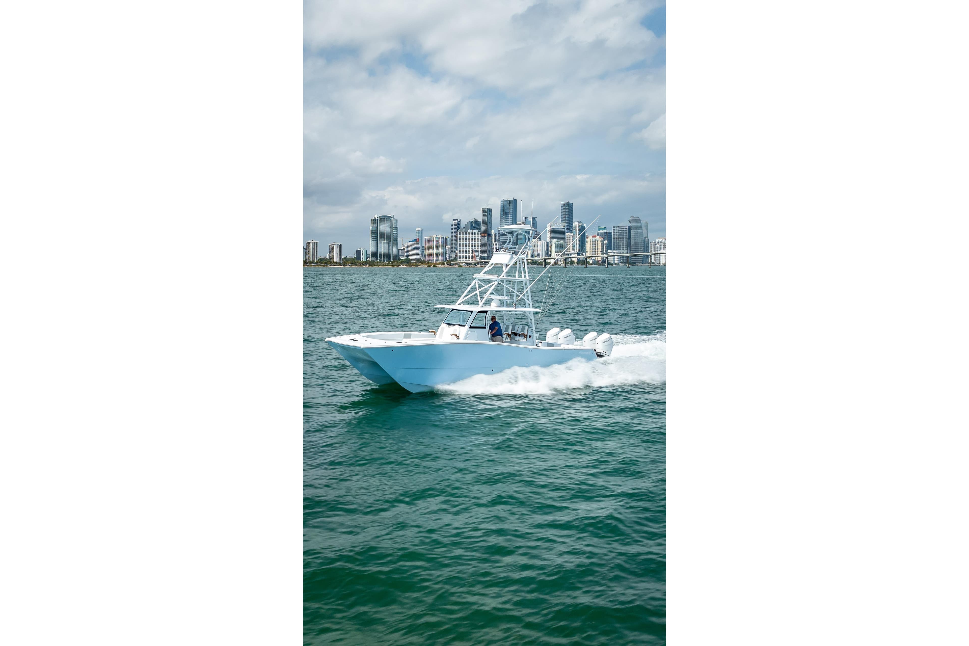 2025 Freeman 43 boat cruising on water with city skyline in background.