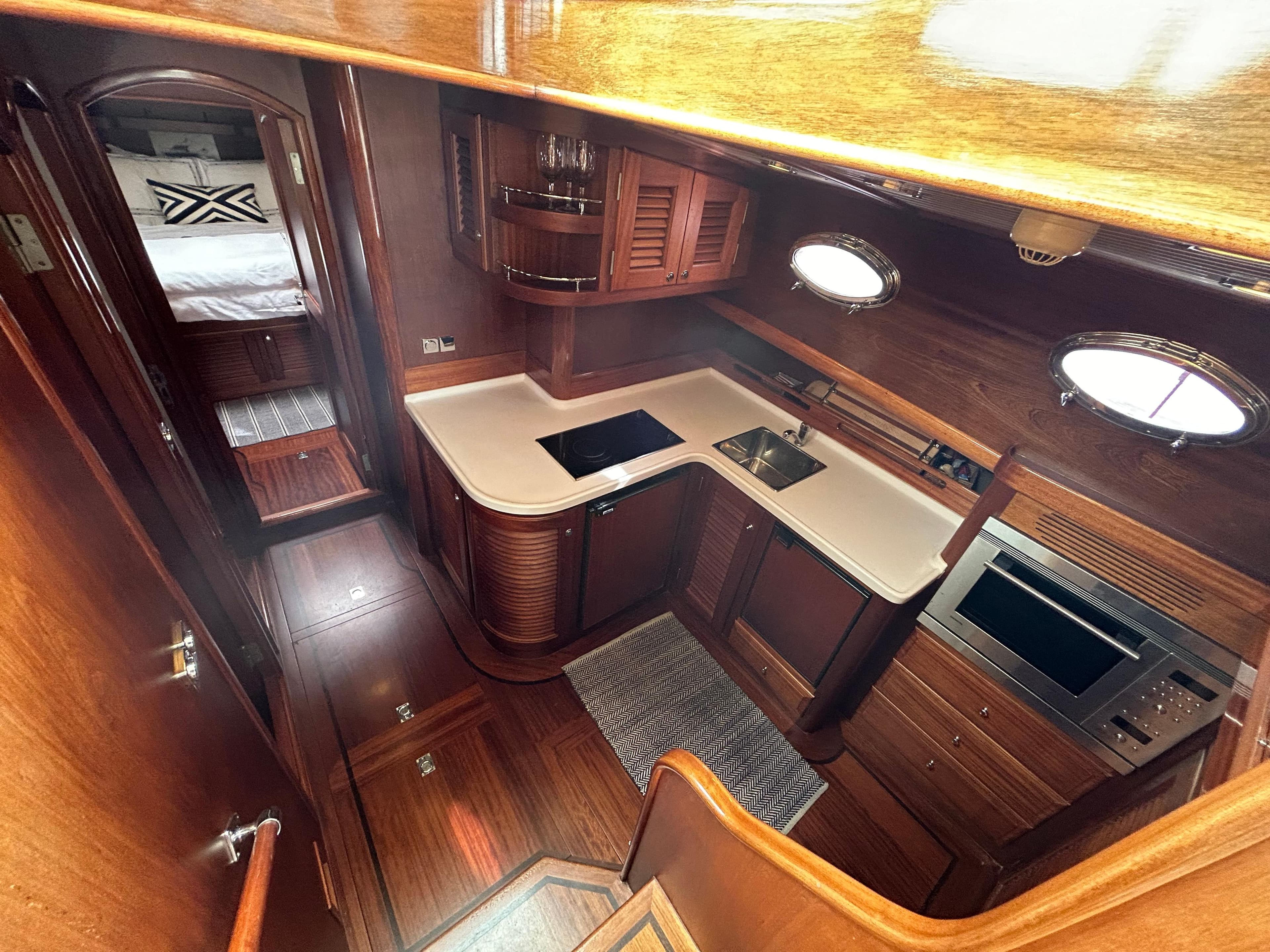 Luxurious 2003 Vicem 51 Classic yacht interior with elegant wood finishes and modern kitchen amenities.