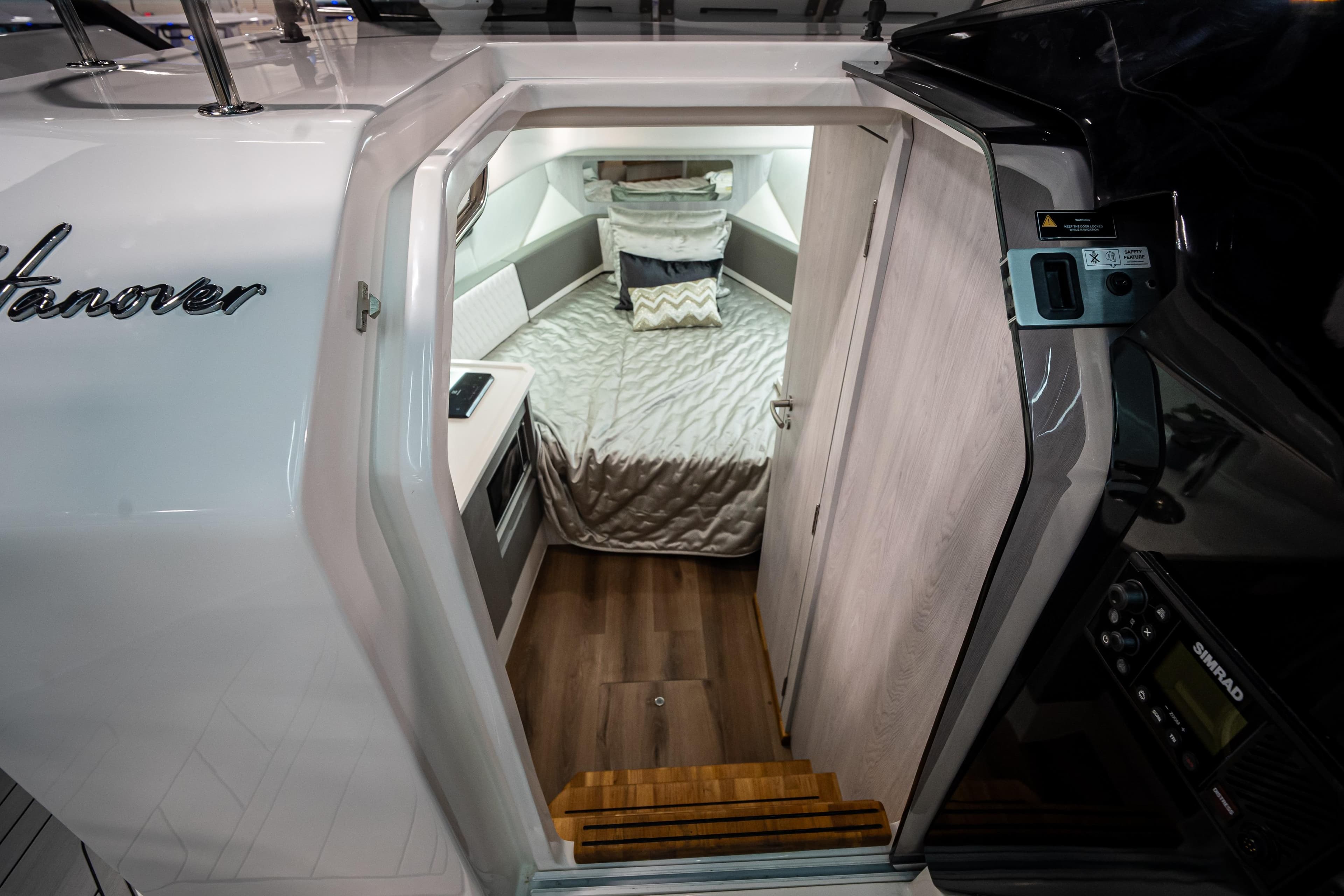 Interior cabin of 2026 Hanover 347 boat with cozy bed and modern design.