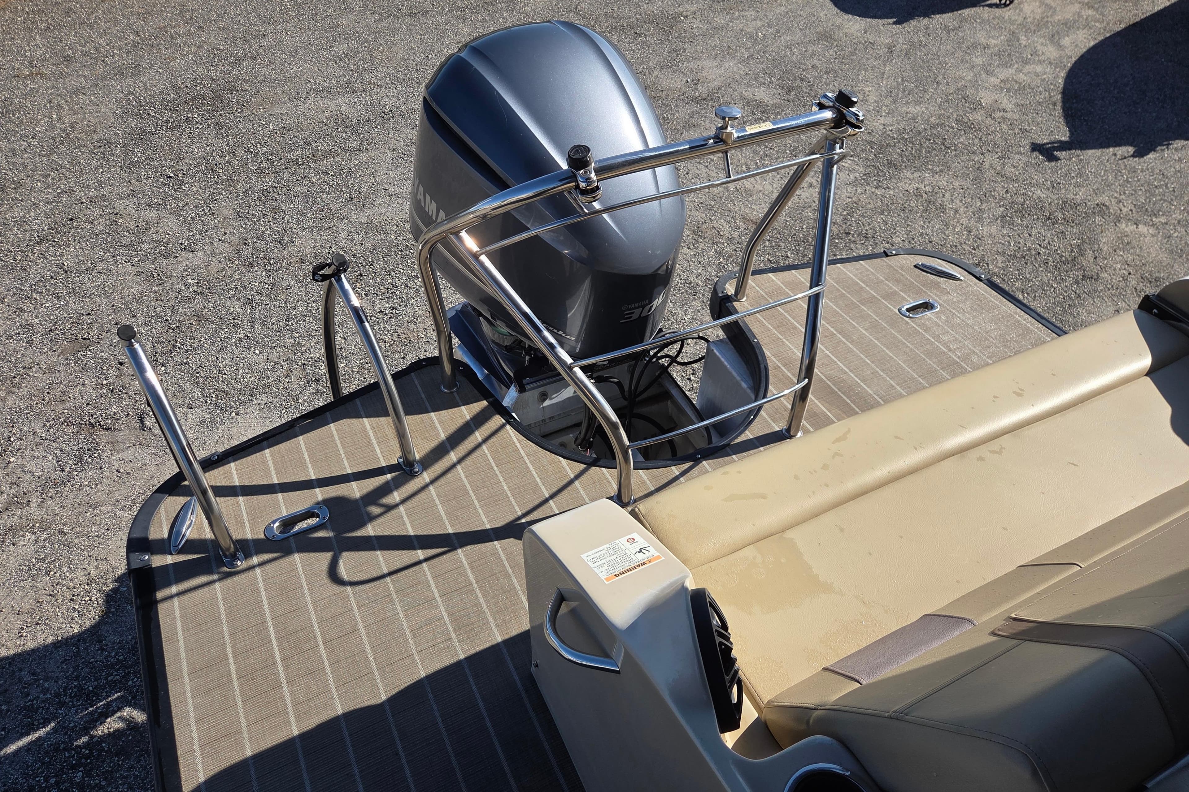 Rear view of 2020 Godfrey AquaPatio 235 C boat with motor and seating area.