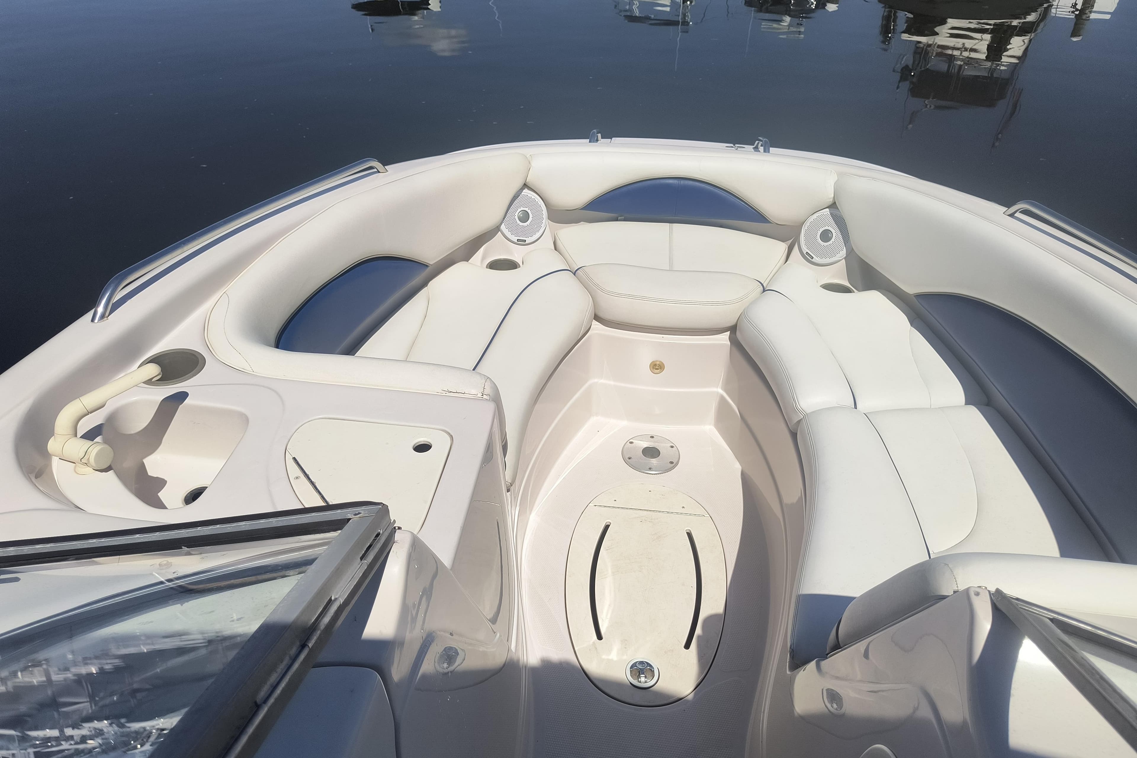 2005 Tahoe 254 boat interior with white seating and cup holders on calm water.