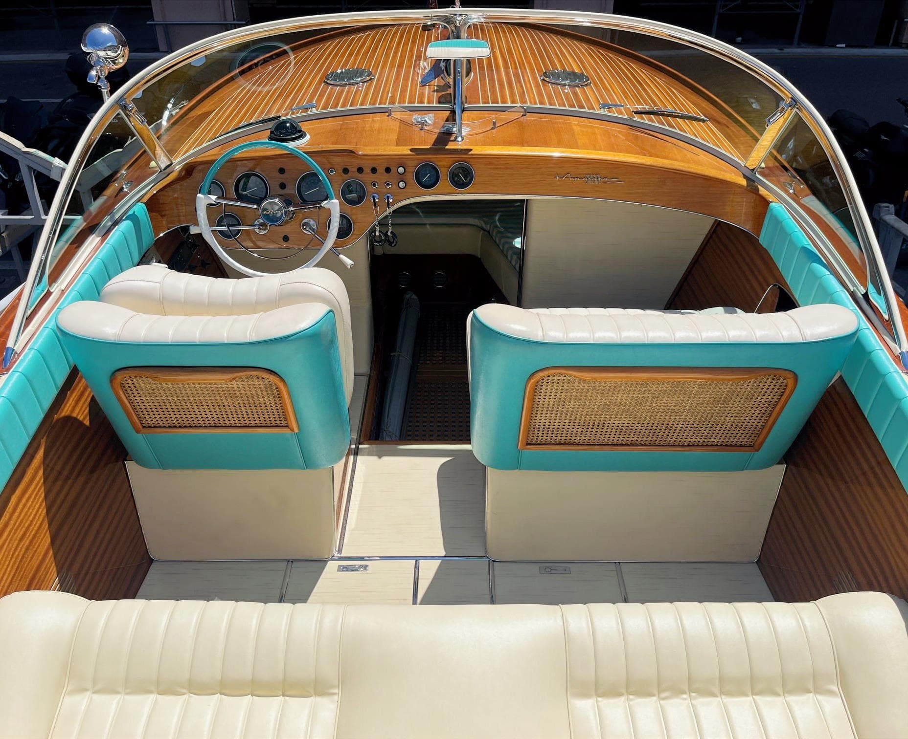 1974 Riva Aquarama Special boat interior with wooden dashboard and turquoise accents.