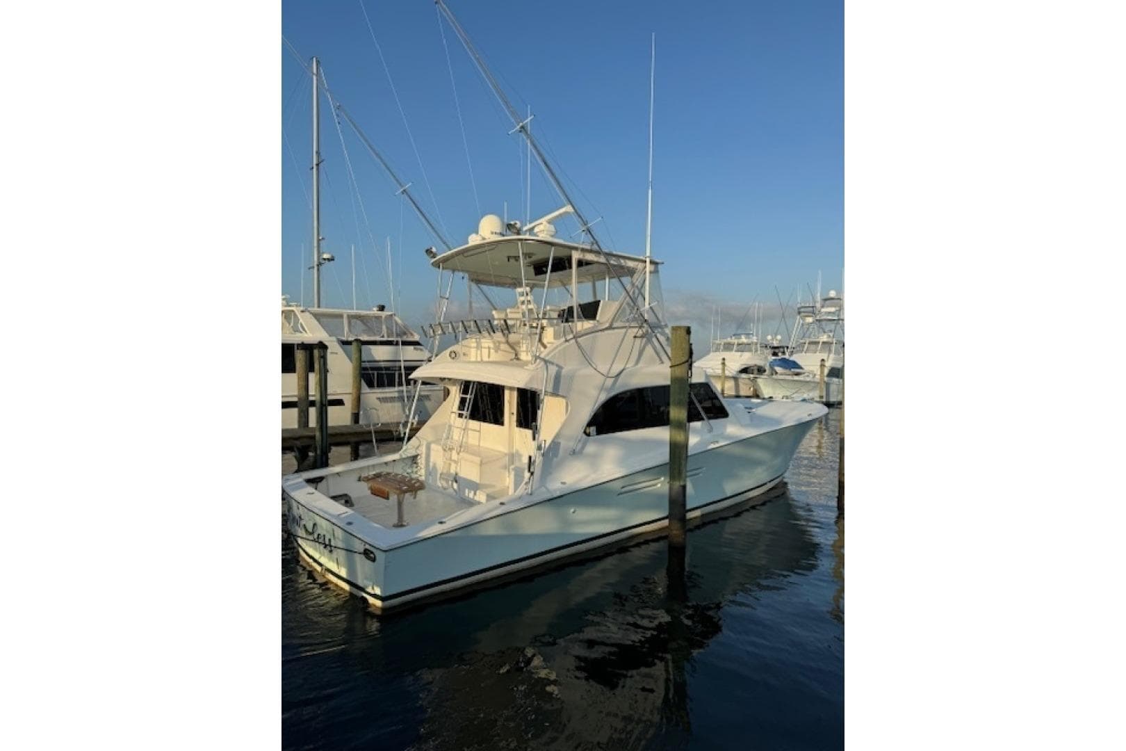 1998 Post 50 yacht docked at marina under clear blue sky.