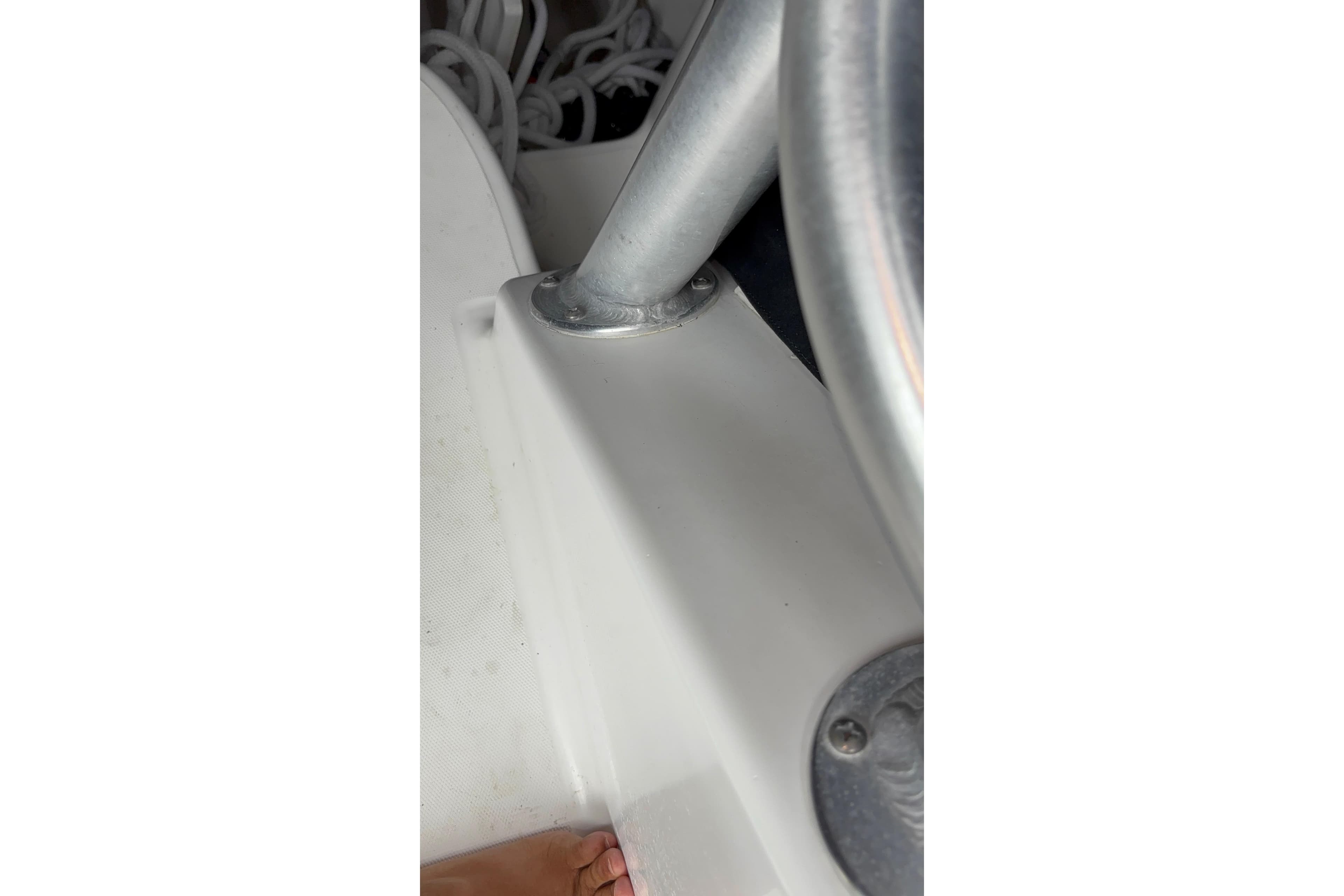 Close-up of 2005 Boston Whaler 305 Conquest boat interior, showing metal fixtures and white surface.