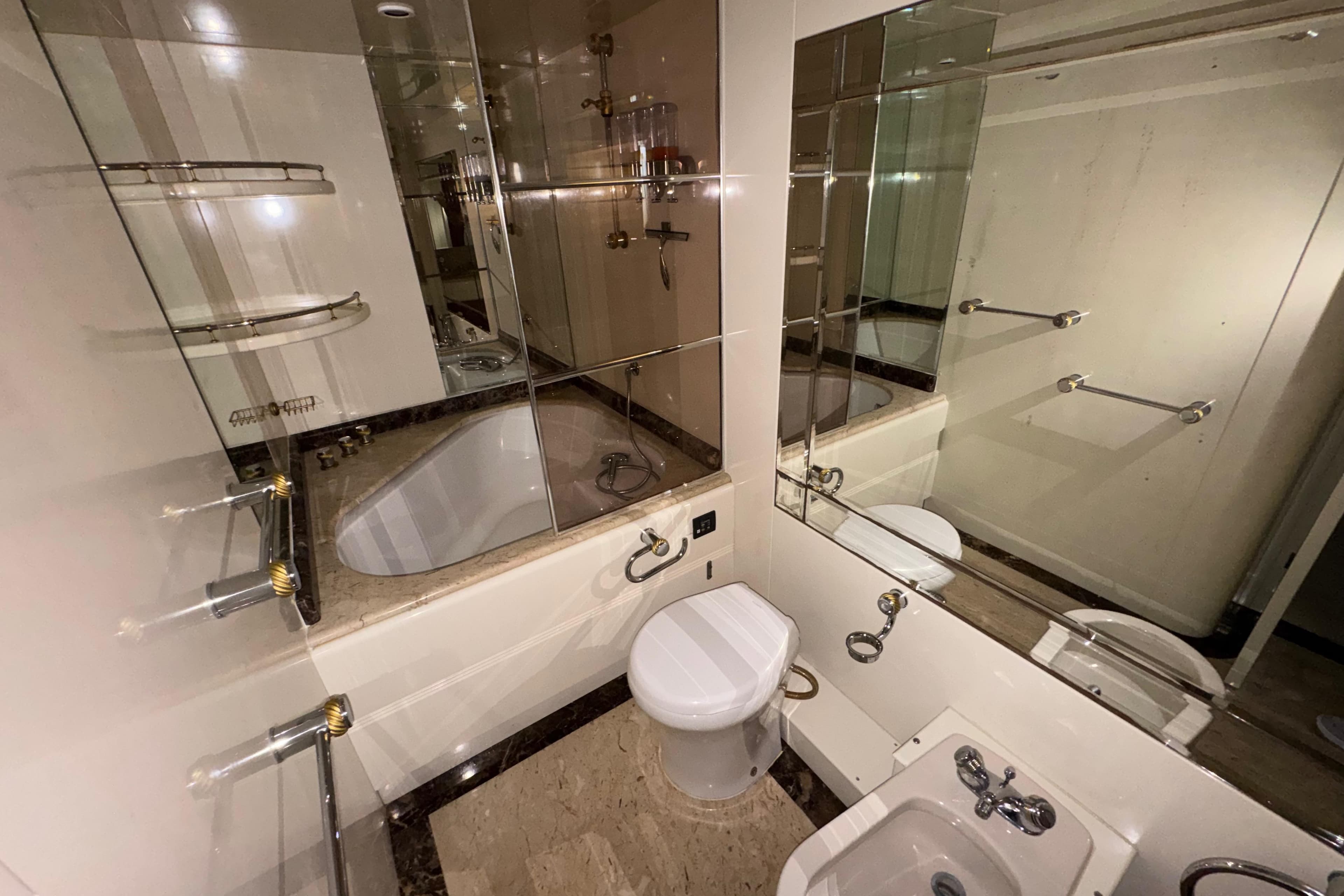 Luxurious bathroom in 1998 Azimut 85 Ultimate yacht with elegant fixtures and mirrored walls.