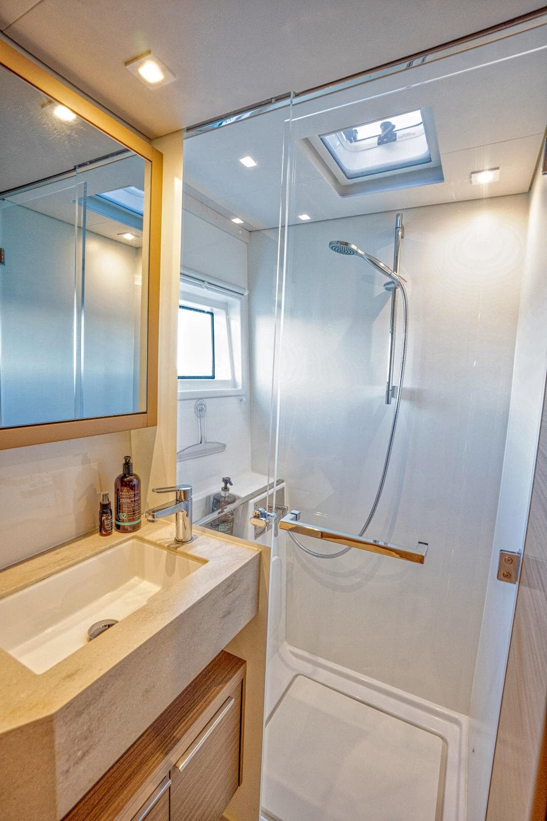 Modern bathroom in 2024 Lagoon 46 yacht with shower and skylight.