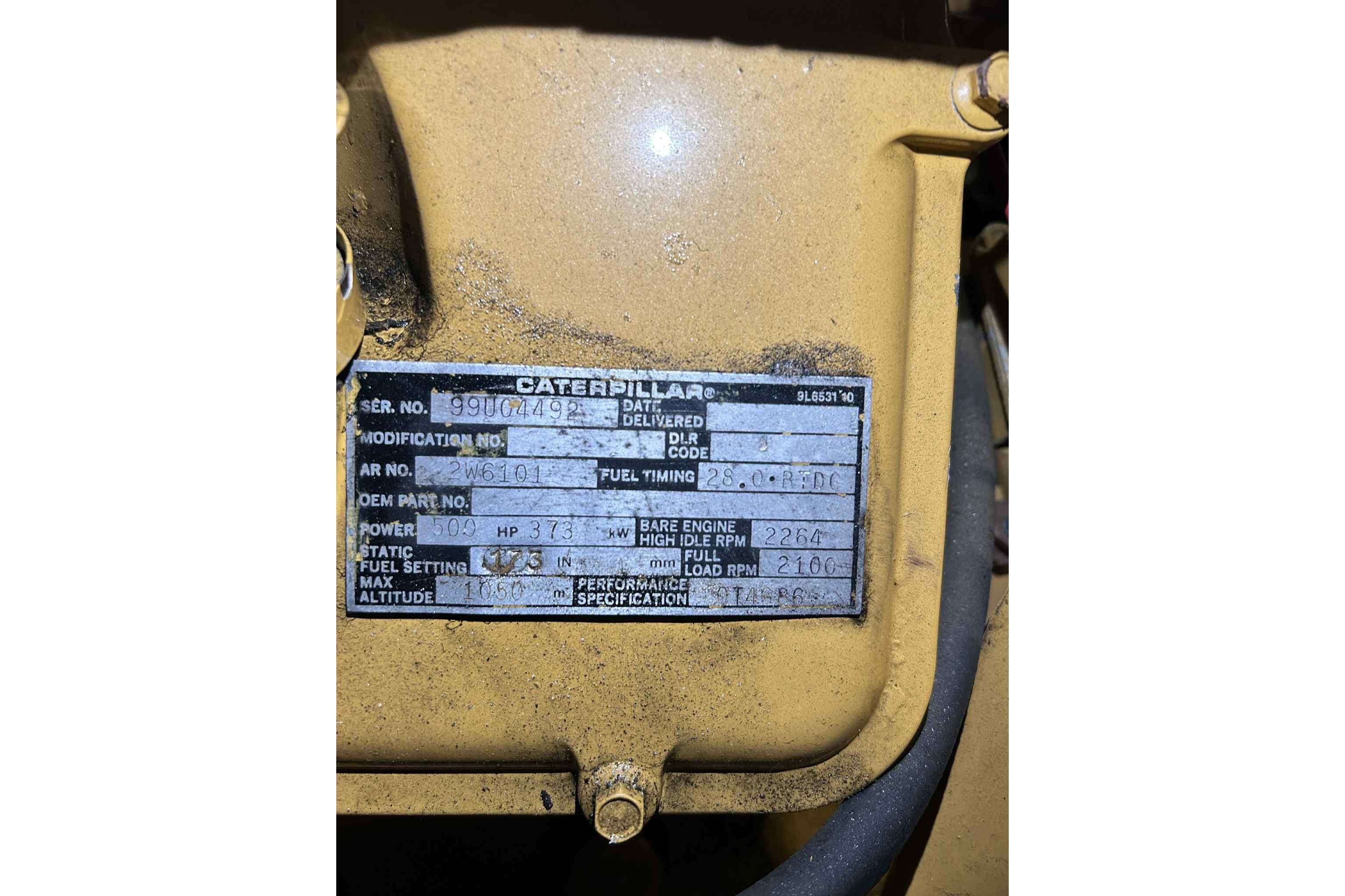 Yellow Caterpillar engine label with specifications, including serial number and power details.