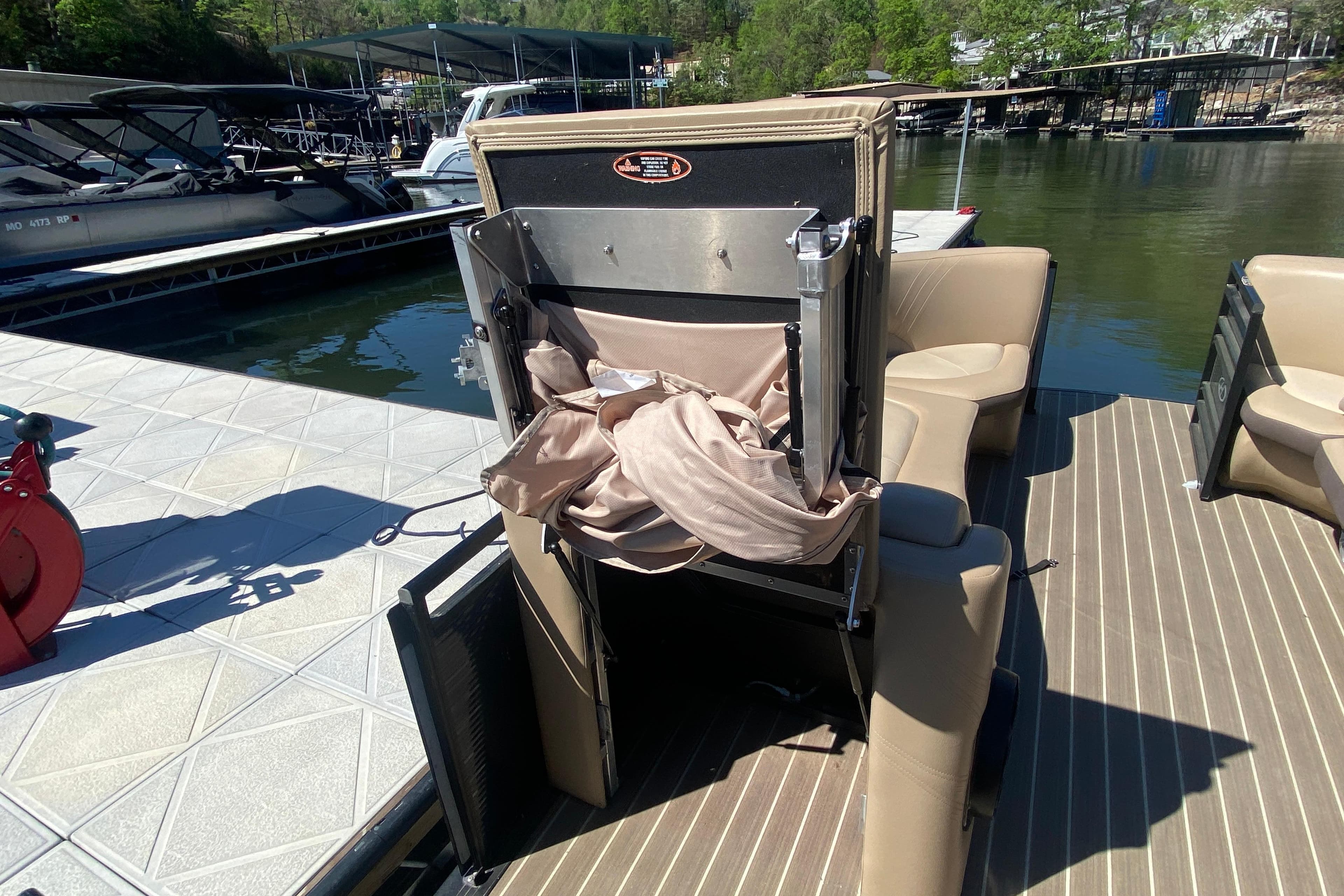 2018 Harris Solstice 240 pontoon boat with seating and storage, docked by the water.