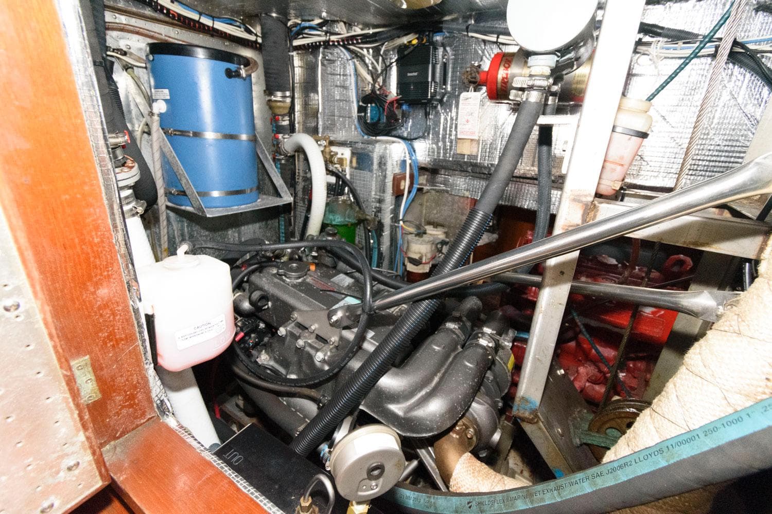 Engine room of a 1988 Tayana 52 sailboat with various mechanical components.
