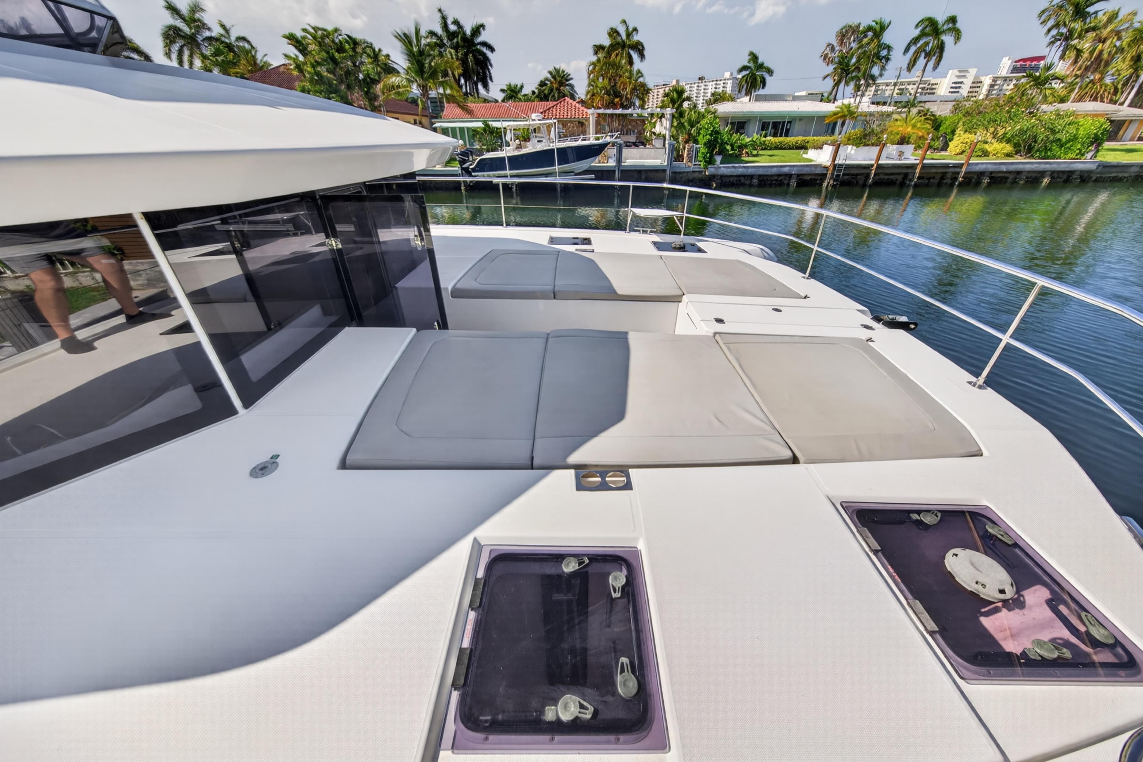 Leopard 53 Powercat 2022 yacht deck with sun loungers and waterfront view.