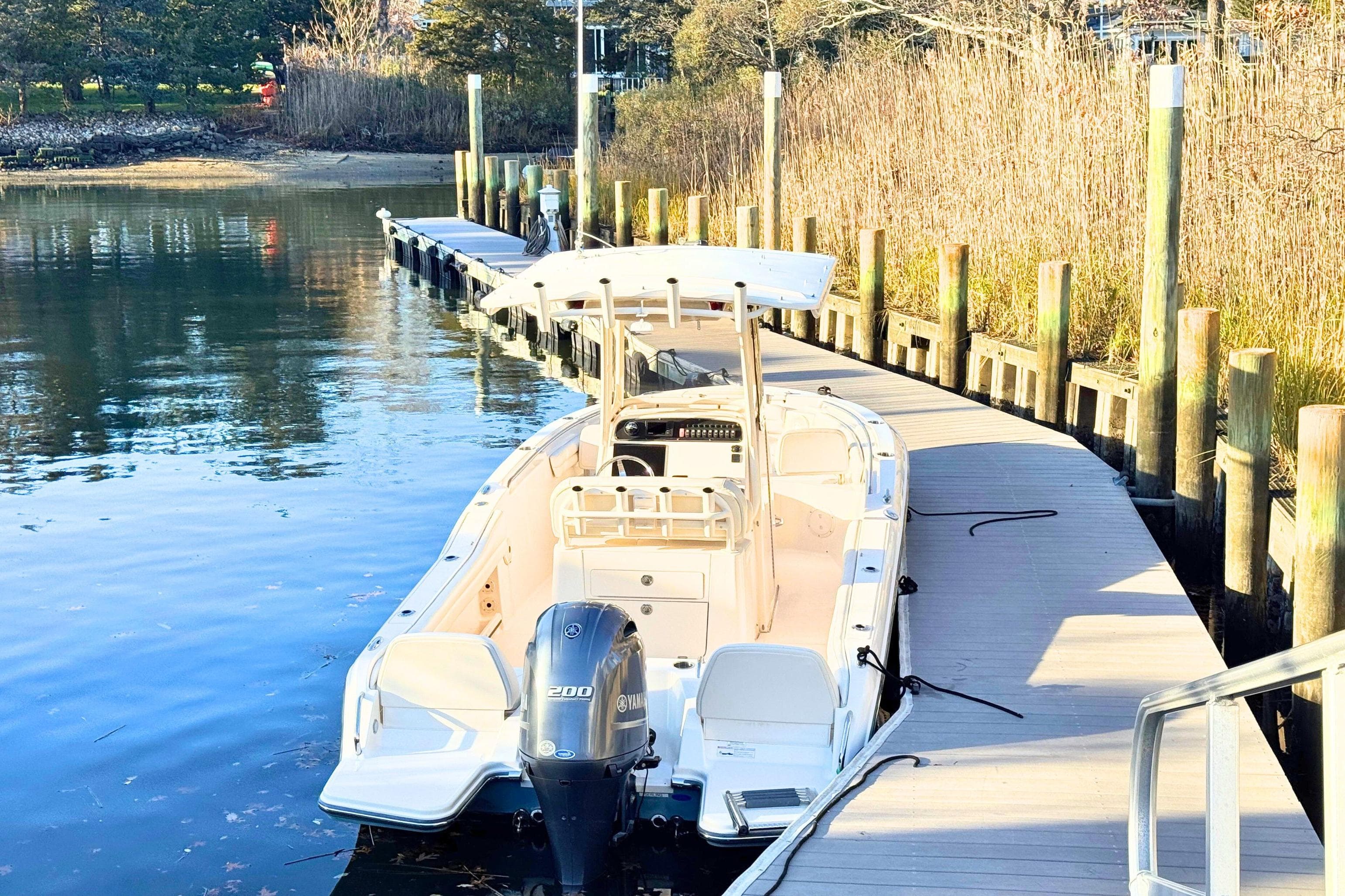 2018 Grady-White Fisherman 216 boat docked by a wooden pier in a serene setting.