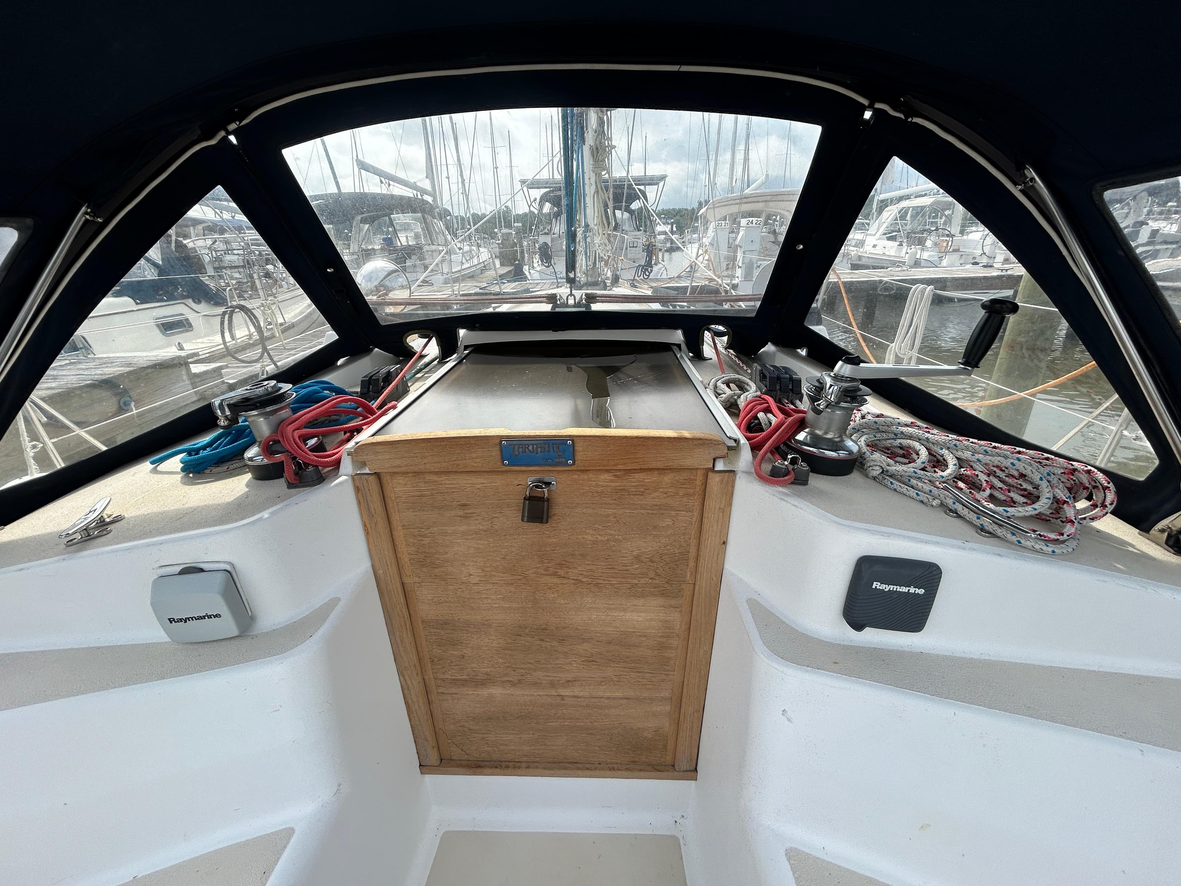 Cockpit of 1998 Tartan 3500 sailboat with ropes and winches, docked at marina.