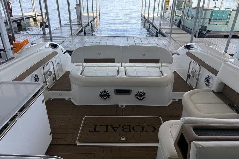 2015 Cobalt A40 boat interior with white seating and wood flooring at a dock.