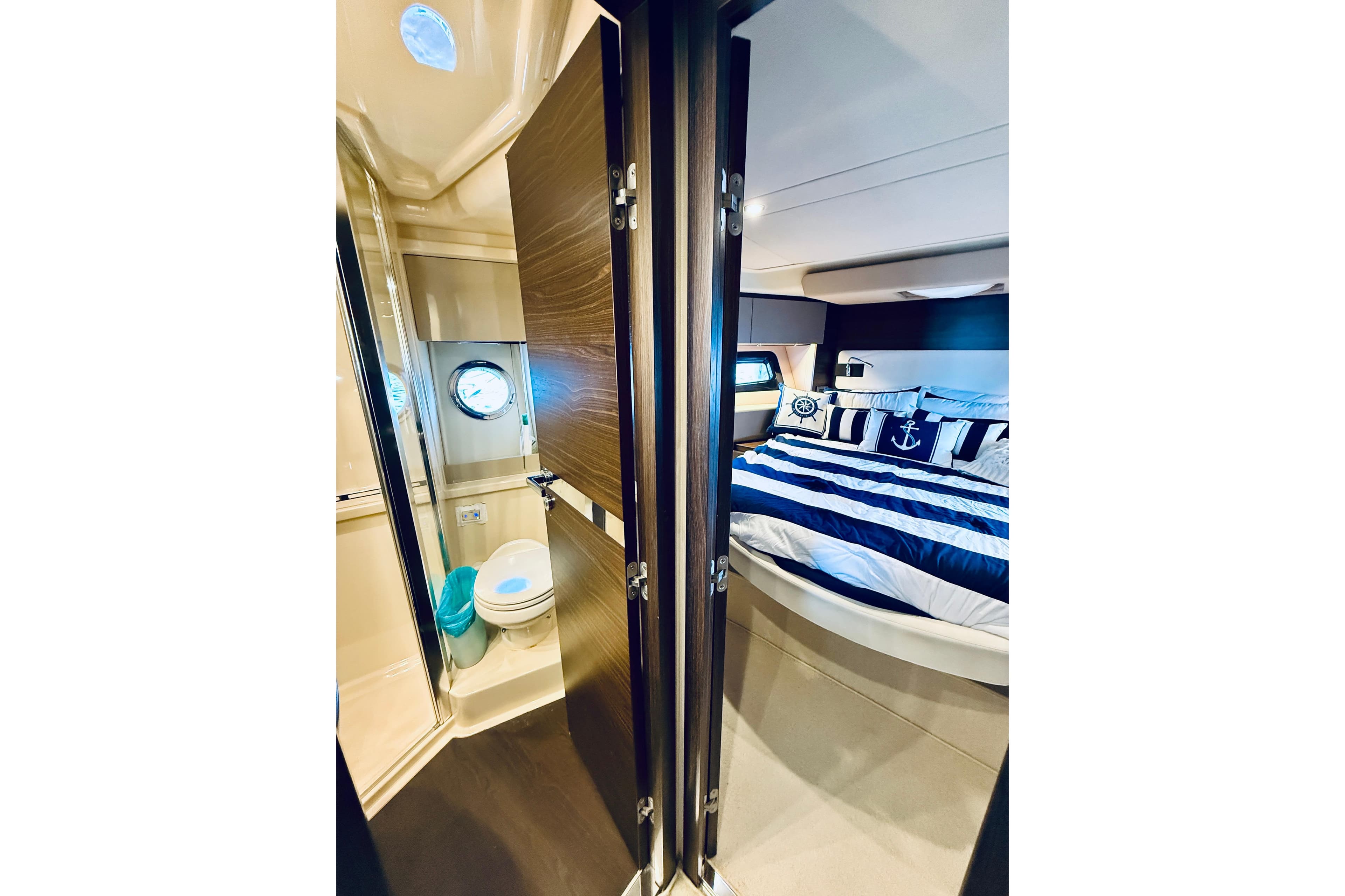 Luxurious 2015 Azimut 50 yacht interior with nautical-themed bedroom and compact bathroom.