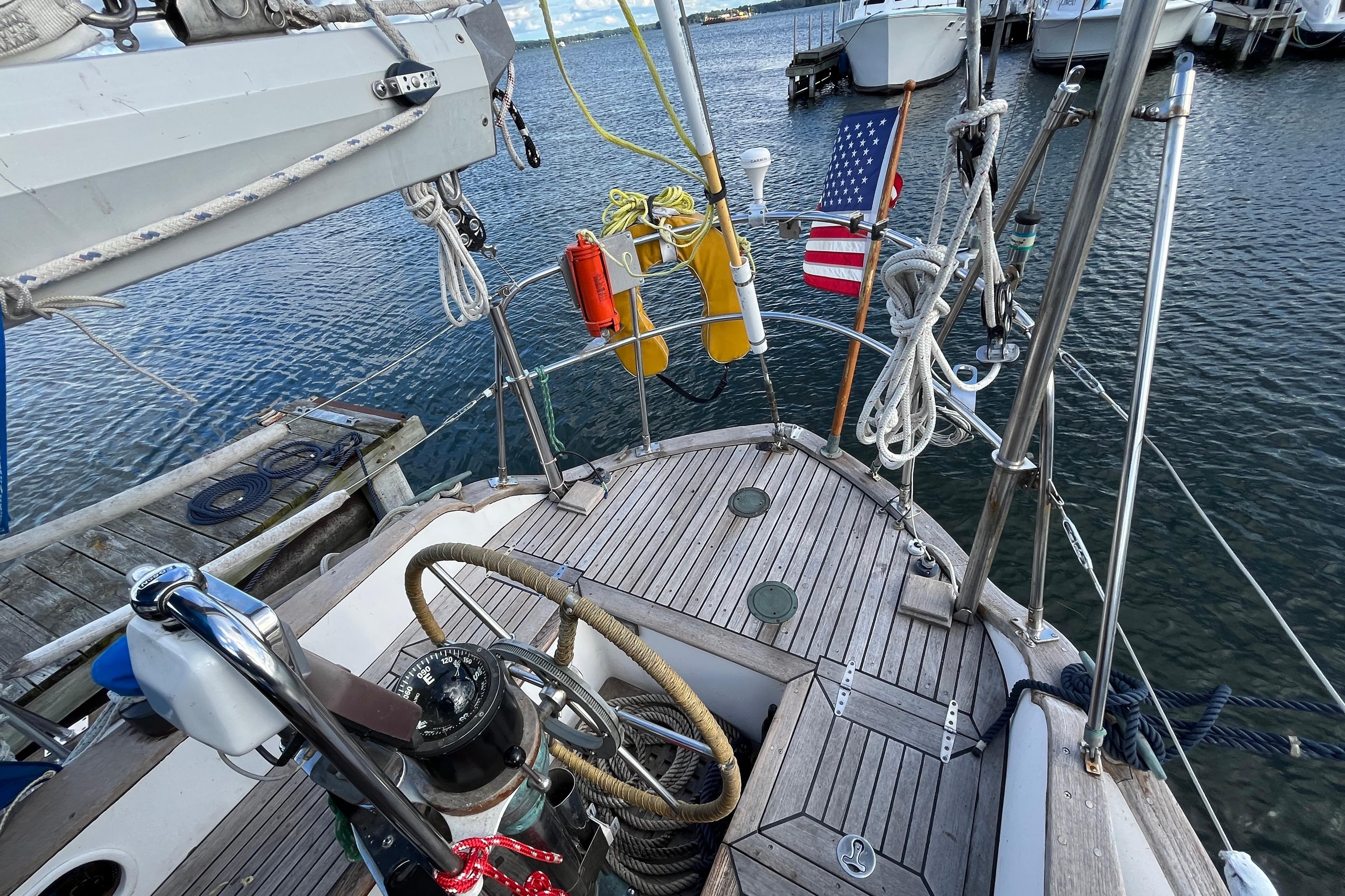 1982 Tayana 37 sailboat deck with nautical equipment and American flag in marina.