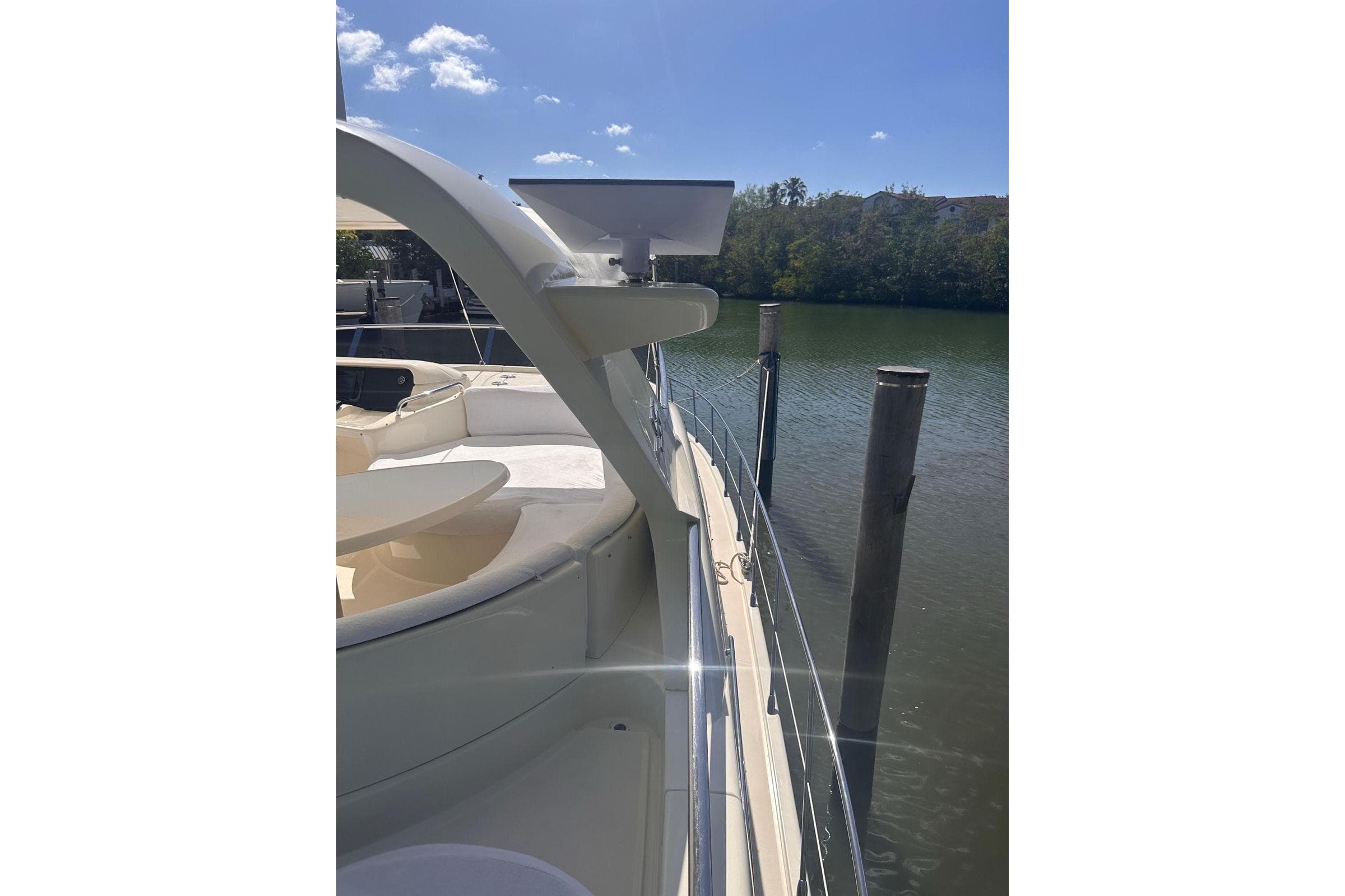 2007 Azimut 55E yacht docked by calm waters under a clear blue sky.