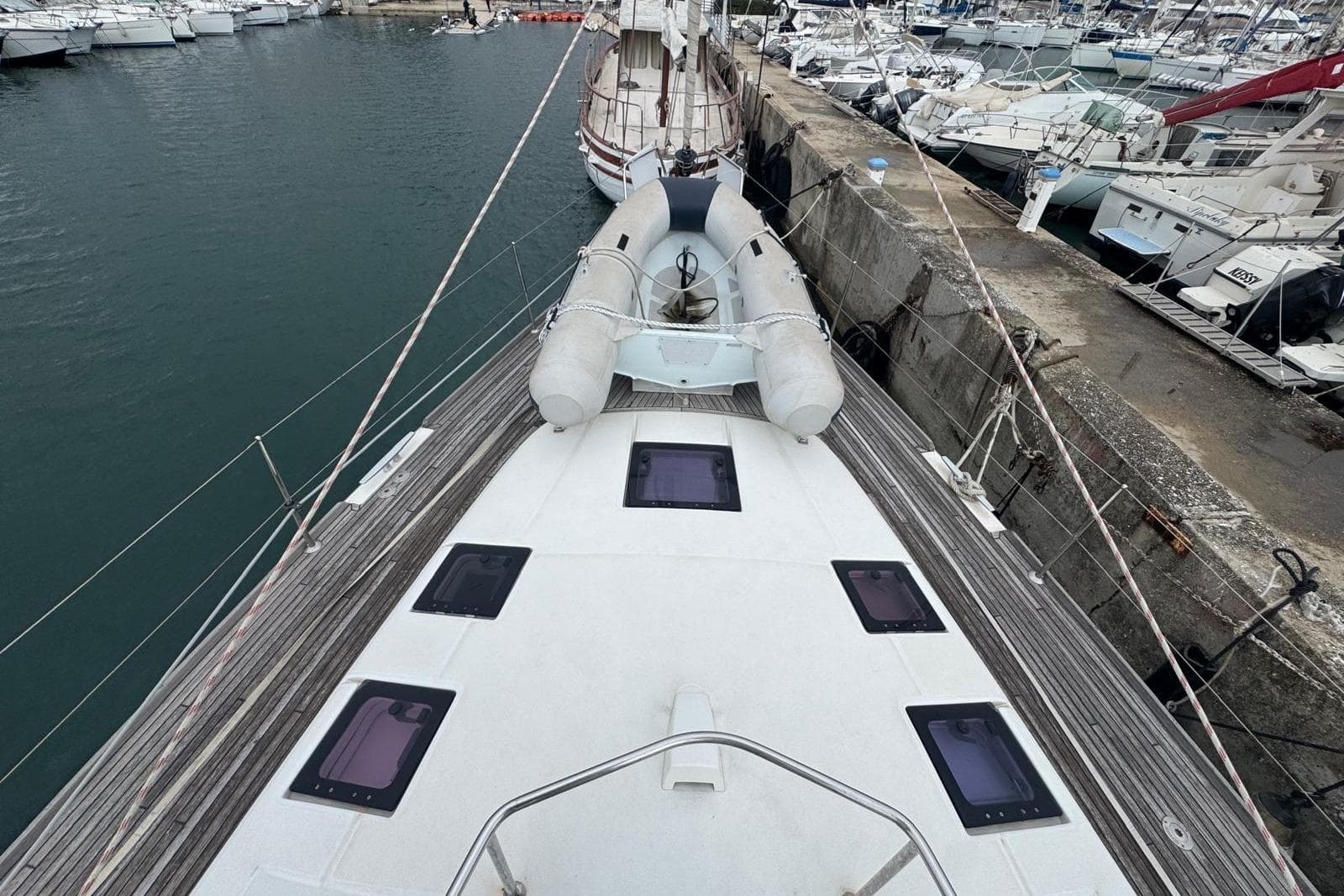 2015 Beneteau Sense 50 yacht docked, featuring a spacious deck and inflatable dinghy.
