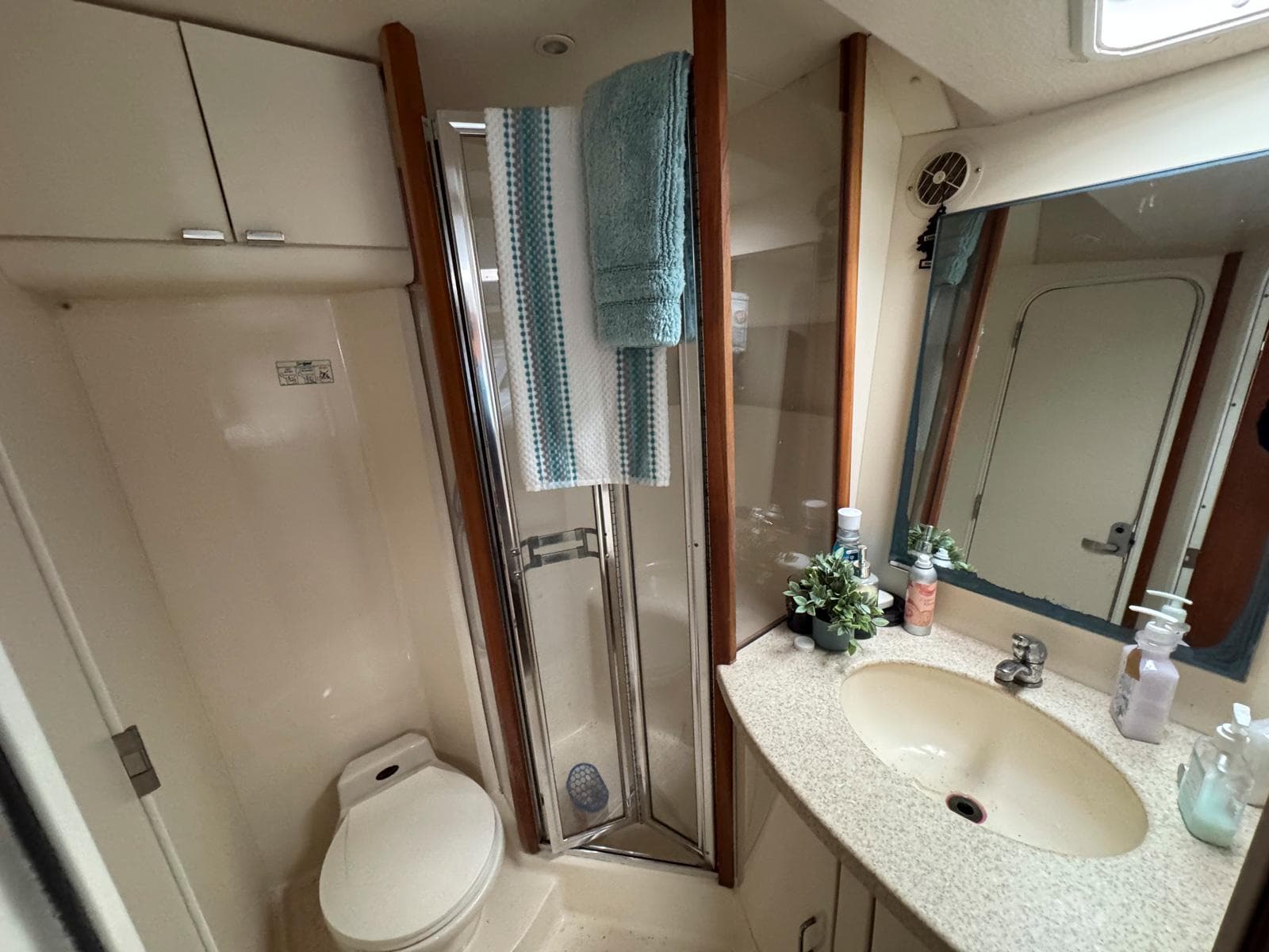 Bathroom interior of 1999 Luhrs 360 Convertible yacht with shower, sink, and toilet.