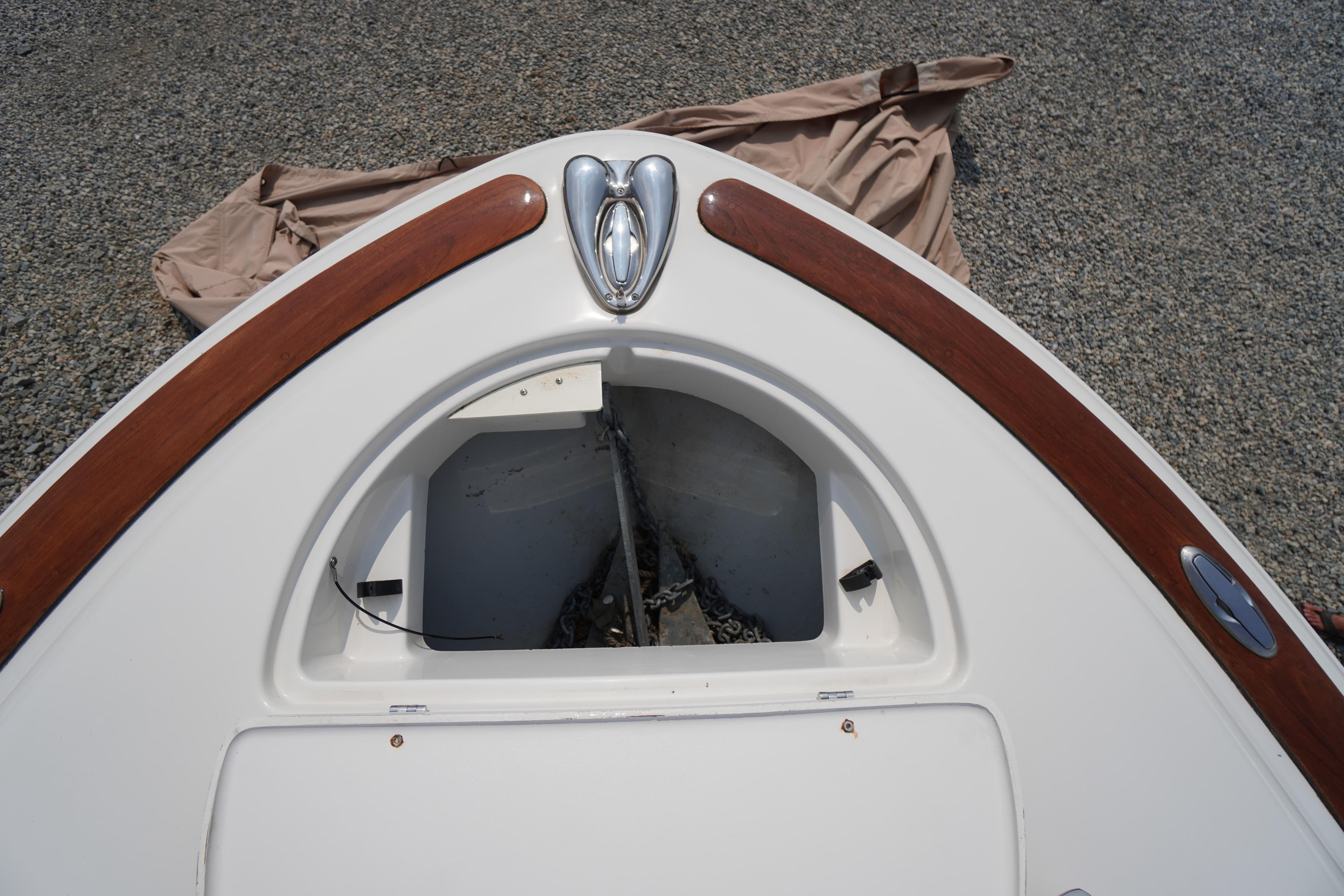 2007 Chris-Craft Corsair 28 boat bow with anchor compartment and wooden trim.