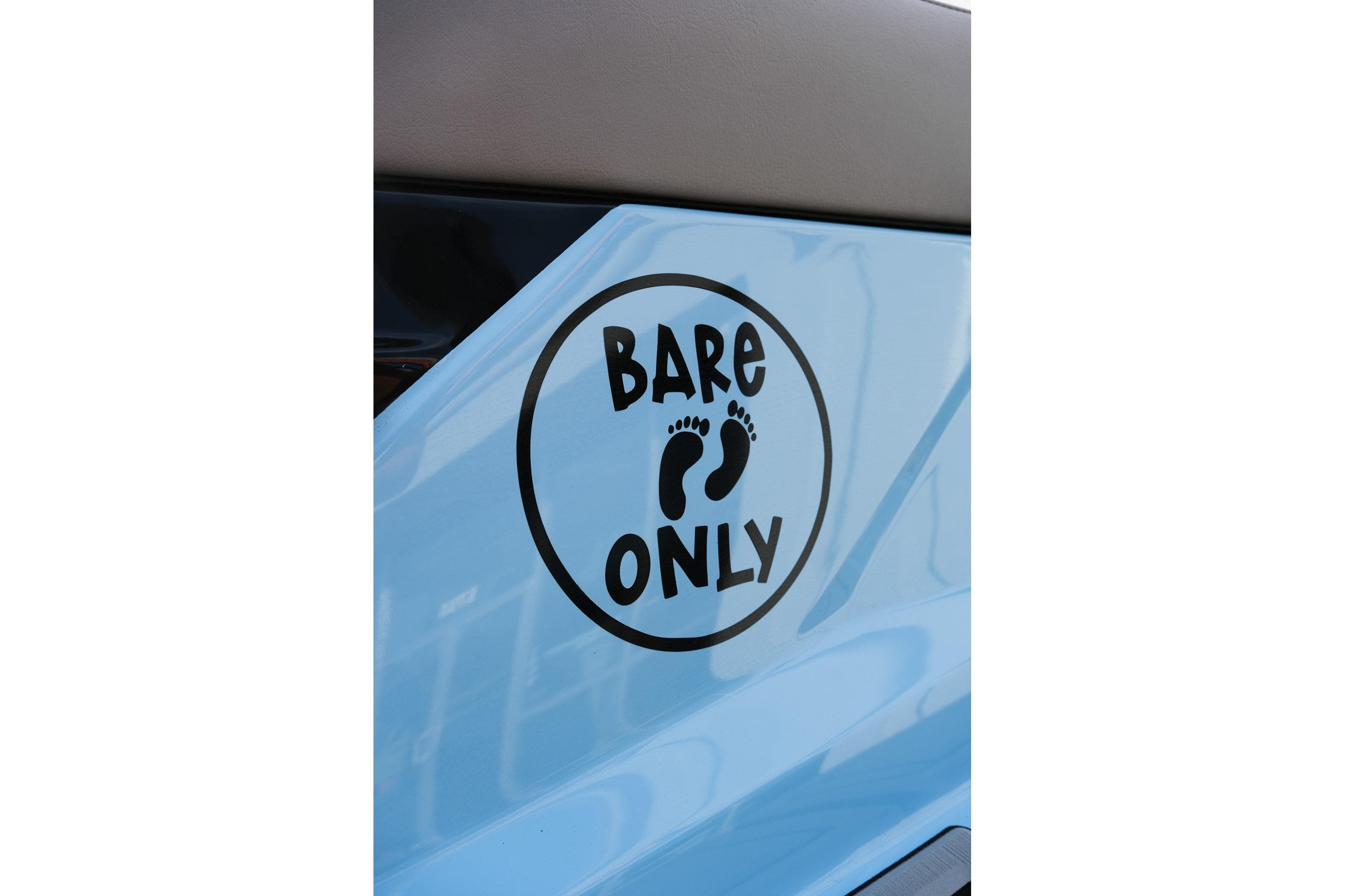 2024 Moomba Tykon boat with 'Bare Only' foot decal on light blue surface.
