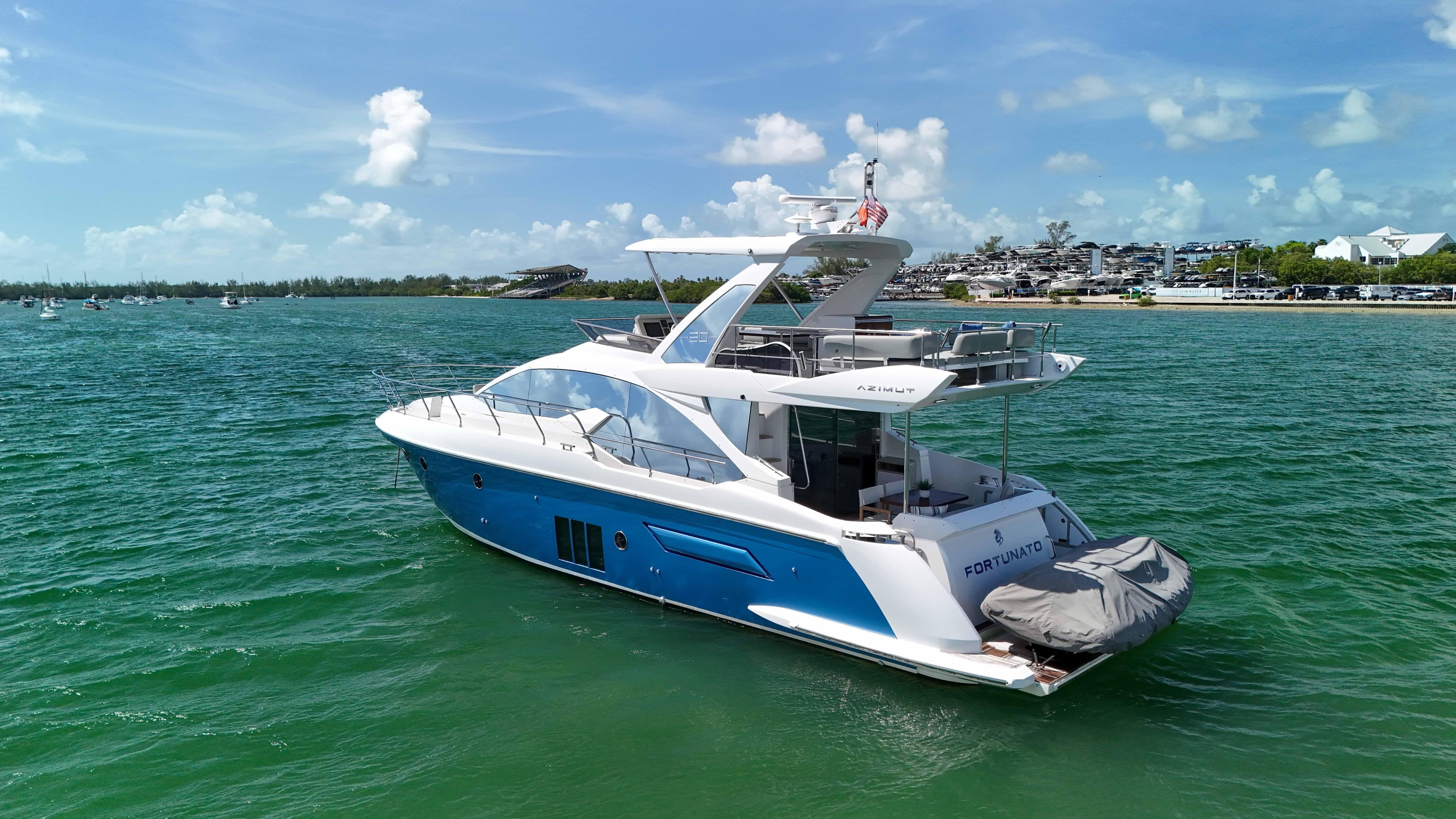 2016 Azimut 50 Flybridge yacht cruising on clear blue waters under a sunny sky.