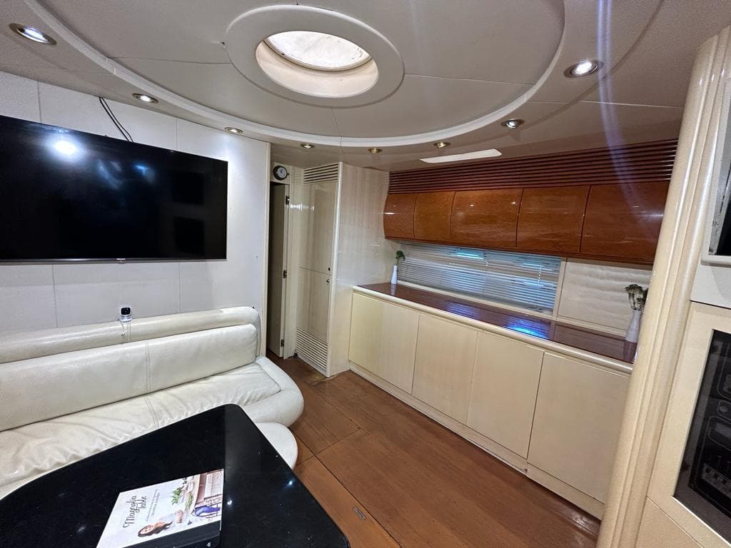 Luxurious interior of 1999 Pershing 54 yacht with modern furnishings and large TV.
