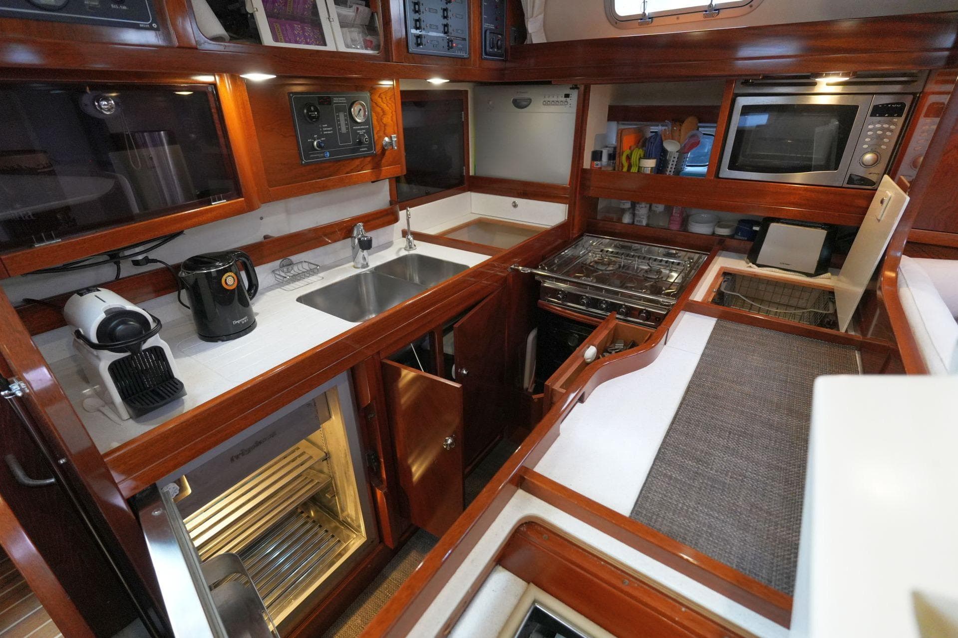 Luxurious 2010 Amel 54 yacht kitchen with modern appliances and wooden cabinetry.