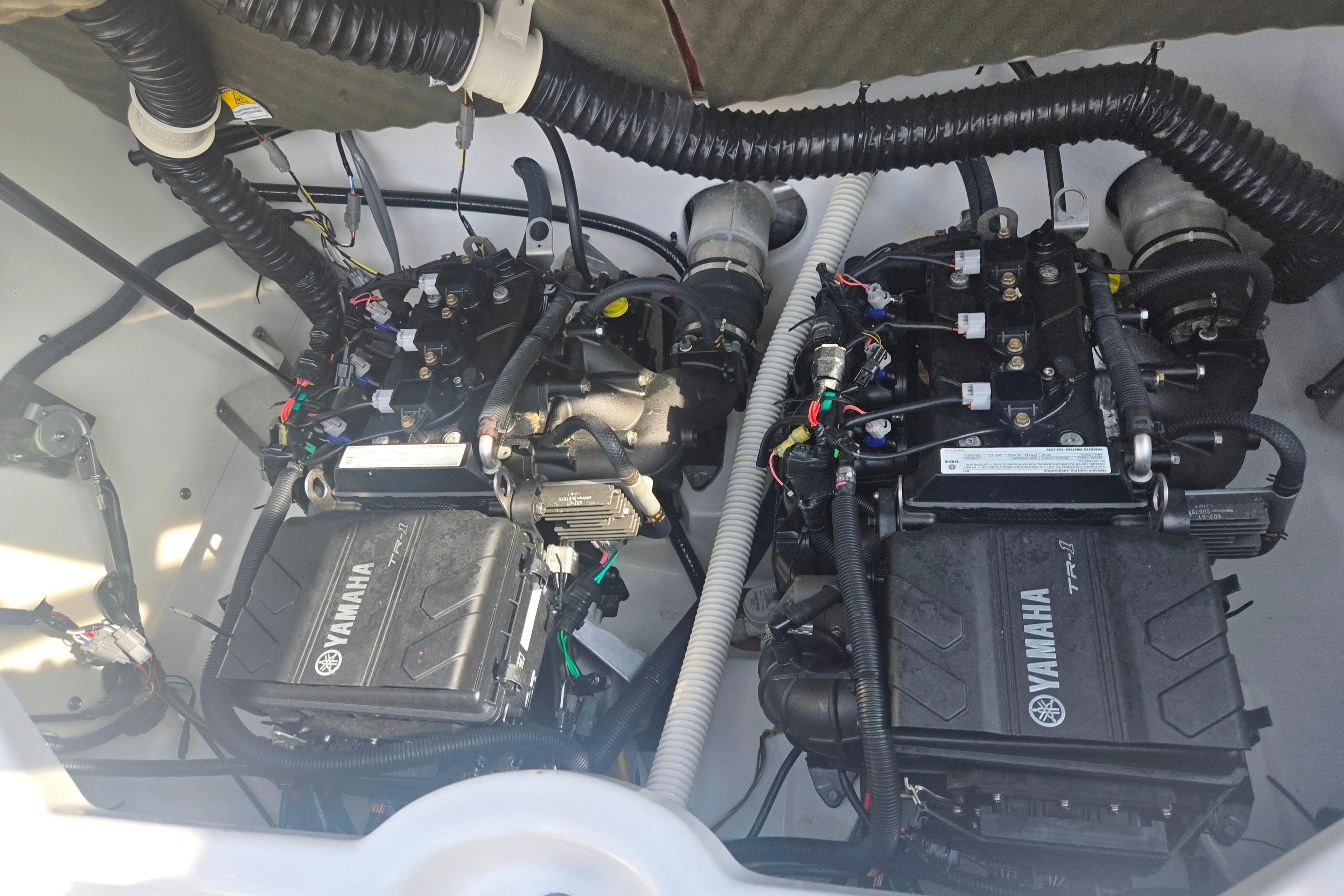 Twin engines of a 2022 Yamaha Boats AR210, showcasing intricate wiring and components.