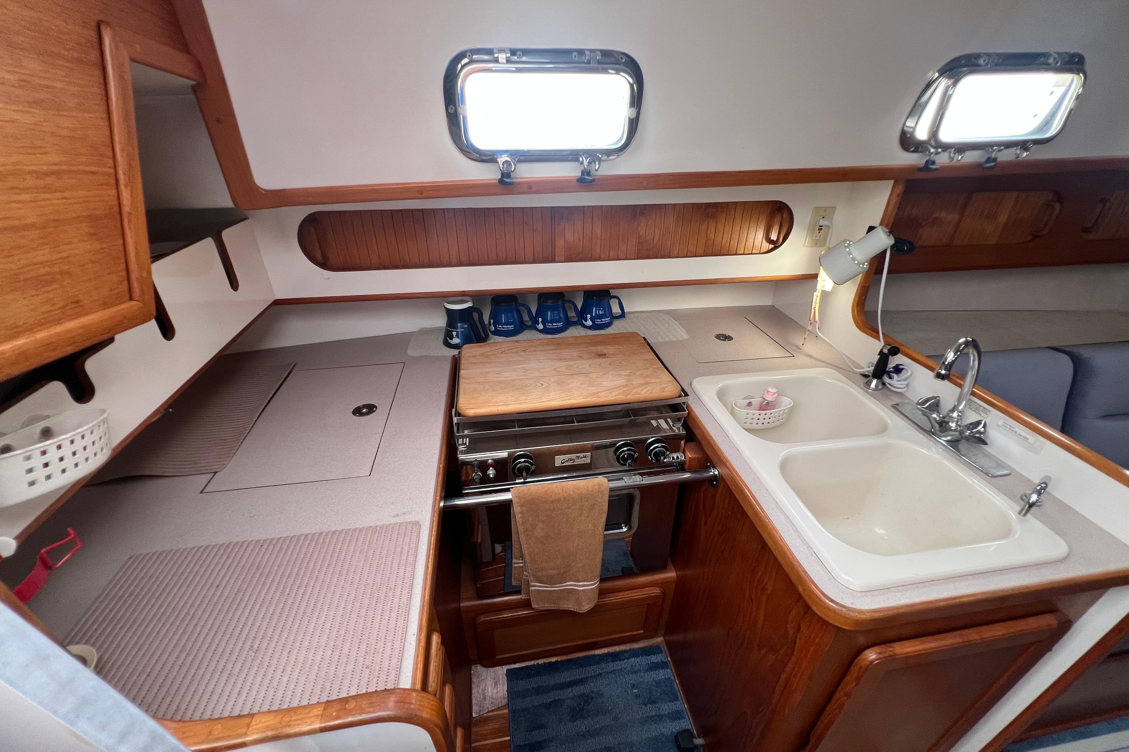 1996 Caliber 35 LRC yacht kitchen with stove, sink, and wooden cabinetry.