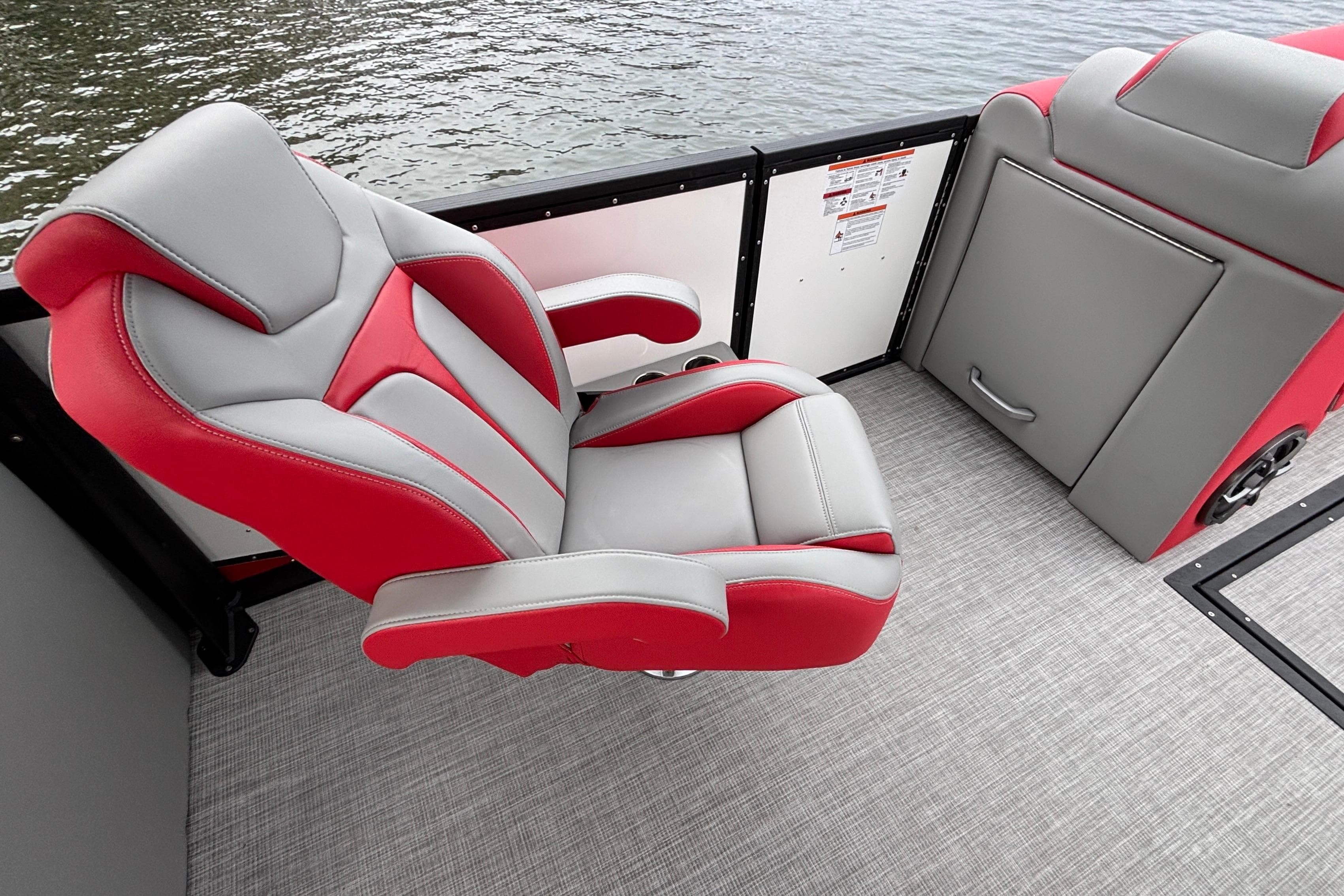 Red and gray captain's chair on 2025 Montara 25 Surf Boss boat interior.