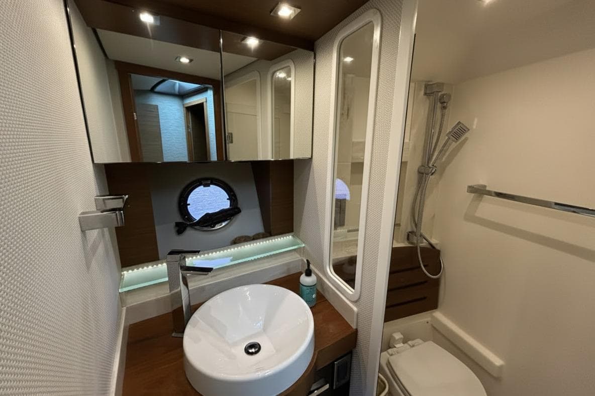 Luxurious bathroom in 2016 Tiara Yachts C44 Coupe with modern fixtures and porthole window.