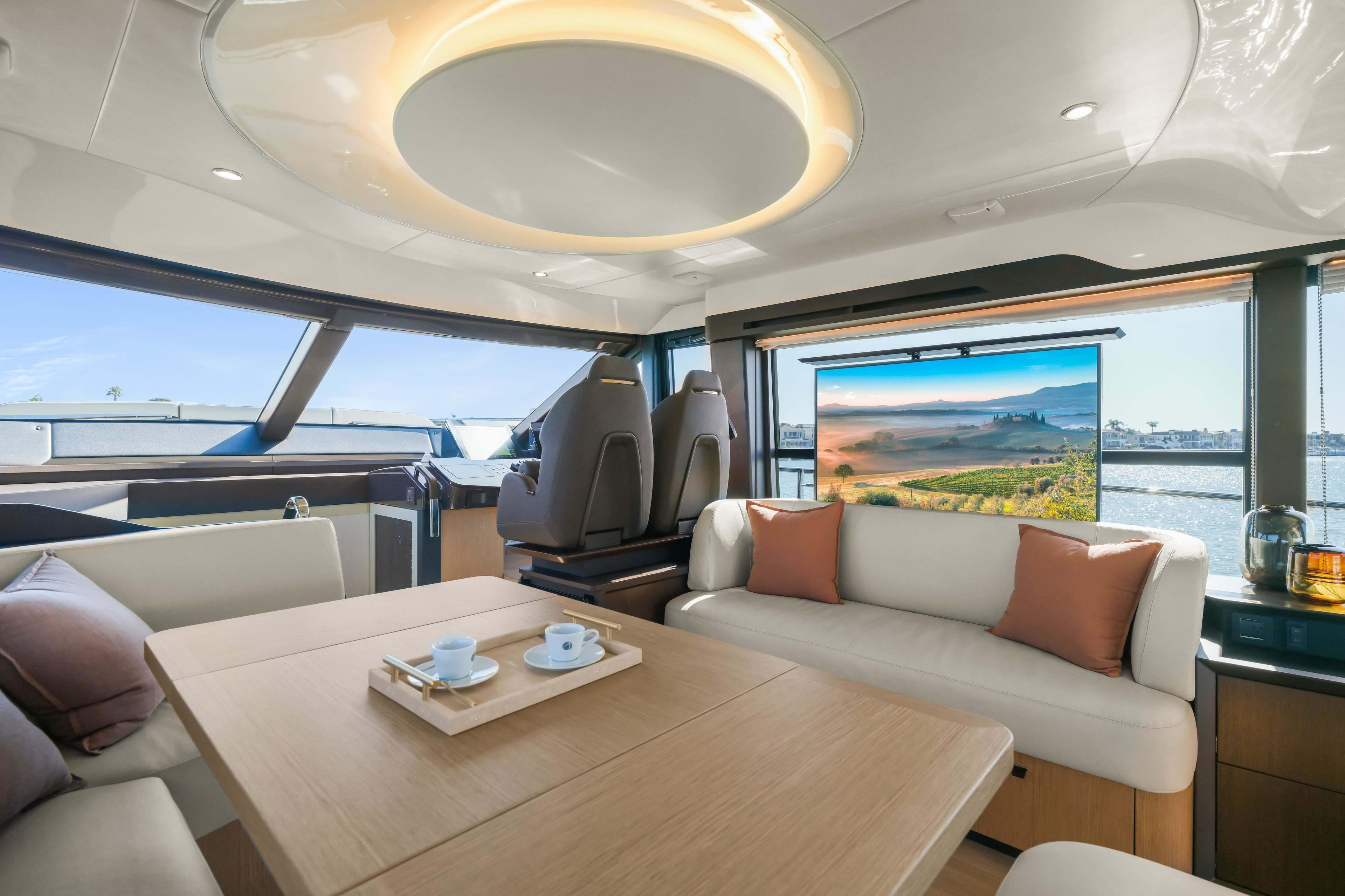 Luxurious interior of 2026 Absolute 52 Fly yacht with modern seating and scenic view.