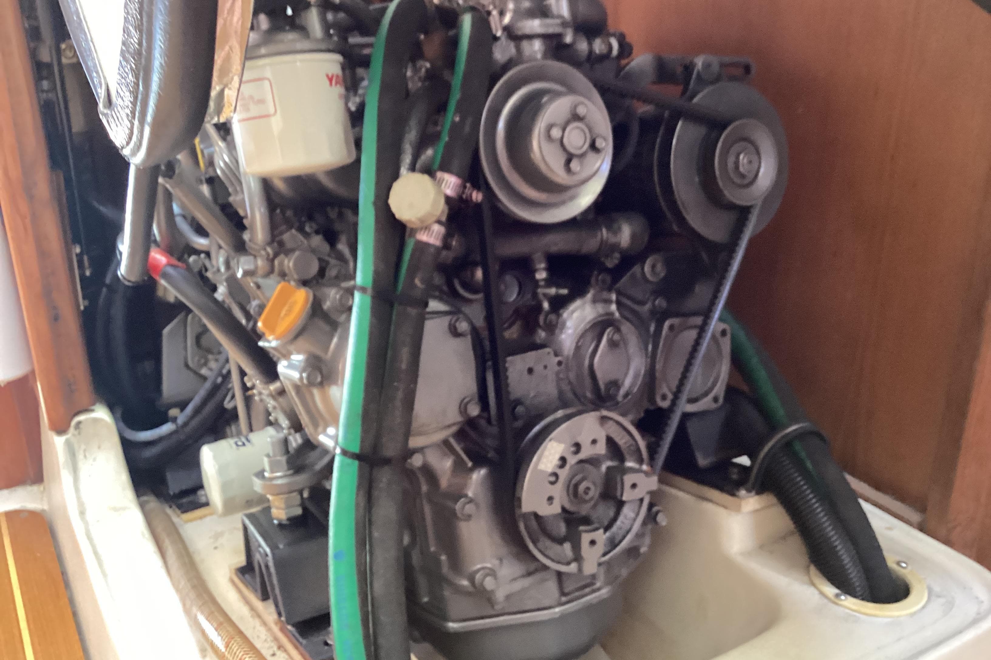 Engine compartment of a 2001 Hunter 380 sailboat, showcasing mechanical components and hoses.