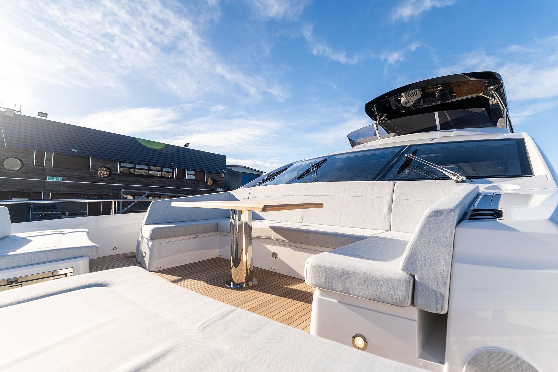 Luxurious 2026 Sunseeker 76 Yacht with spacious deck seating under clear blue skies.