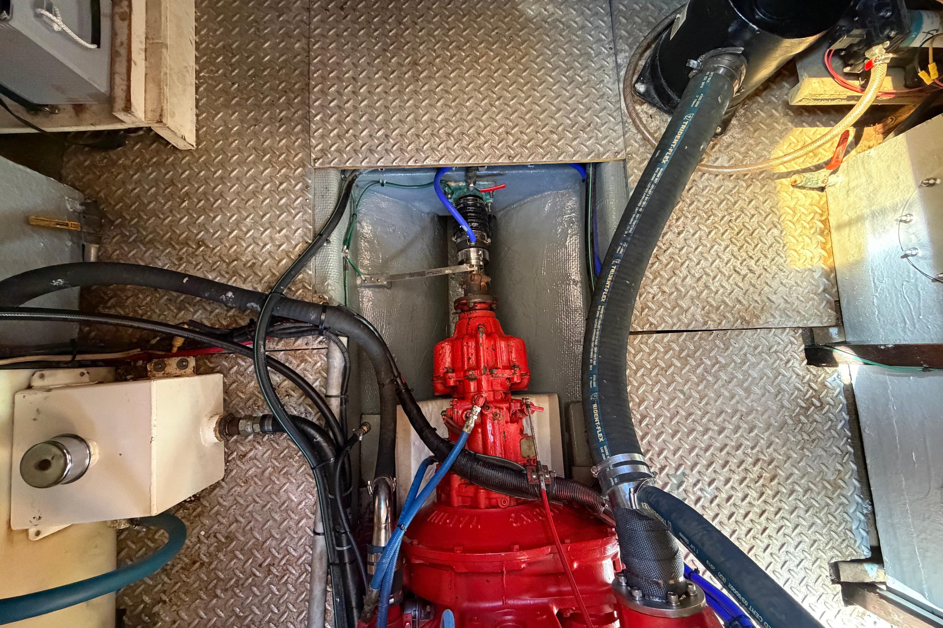 Engine room of 1982 Lien Hwa 31 boat with visible red machinery and hoses.