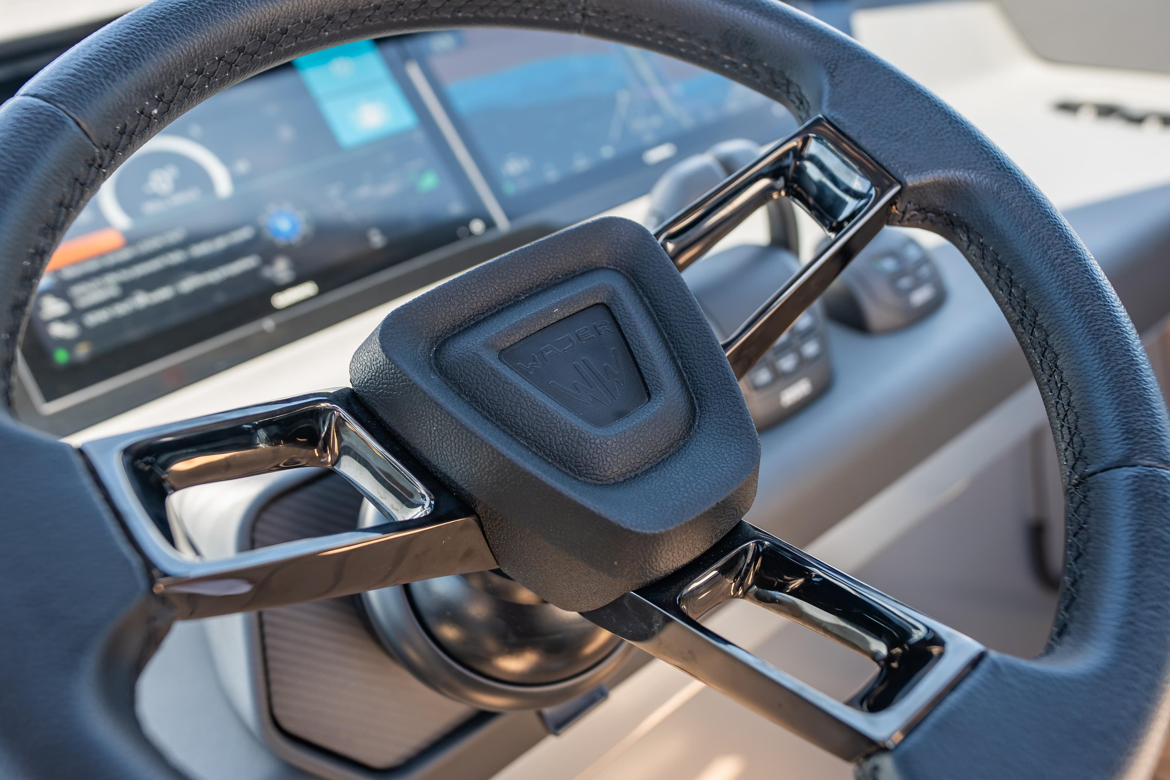 Steering wheel of Wajer 77 yacht with digital dashboard display.