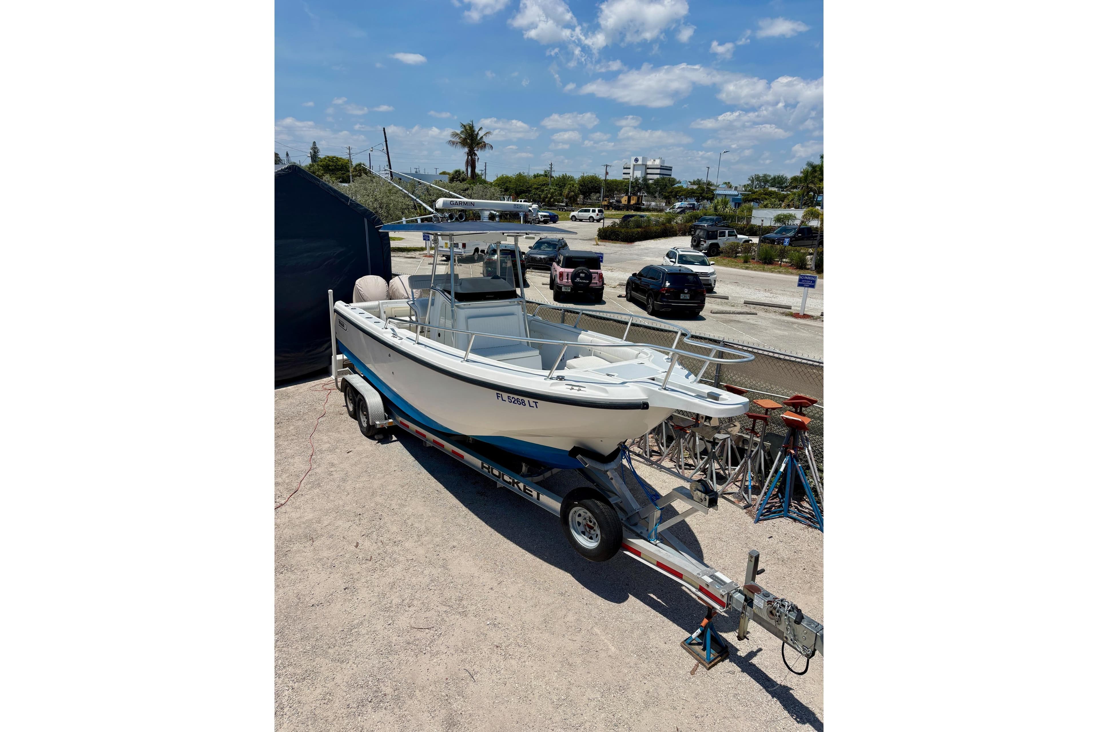 2001 Boston Whaler 26 Outrage boat on trailer in sunny parking lot.