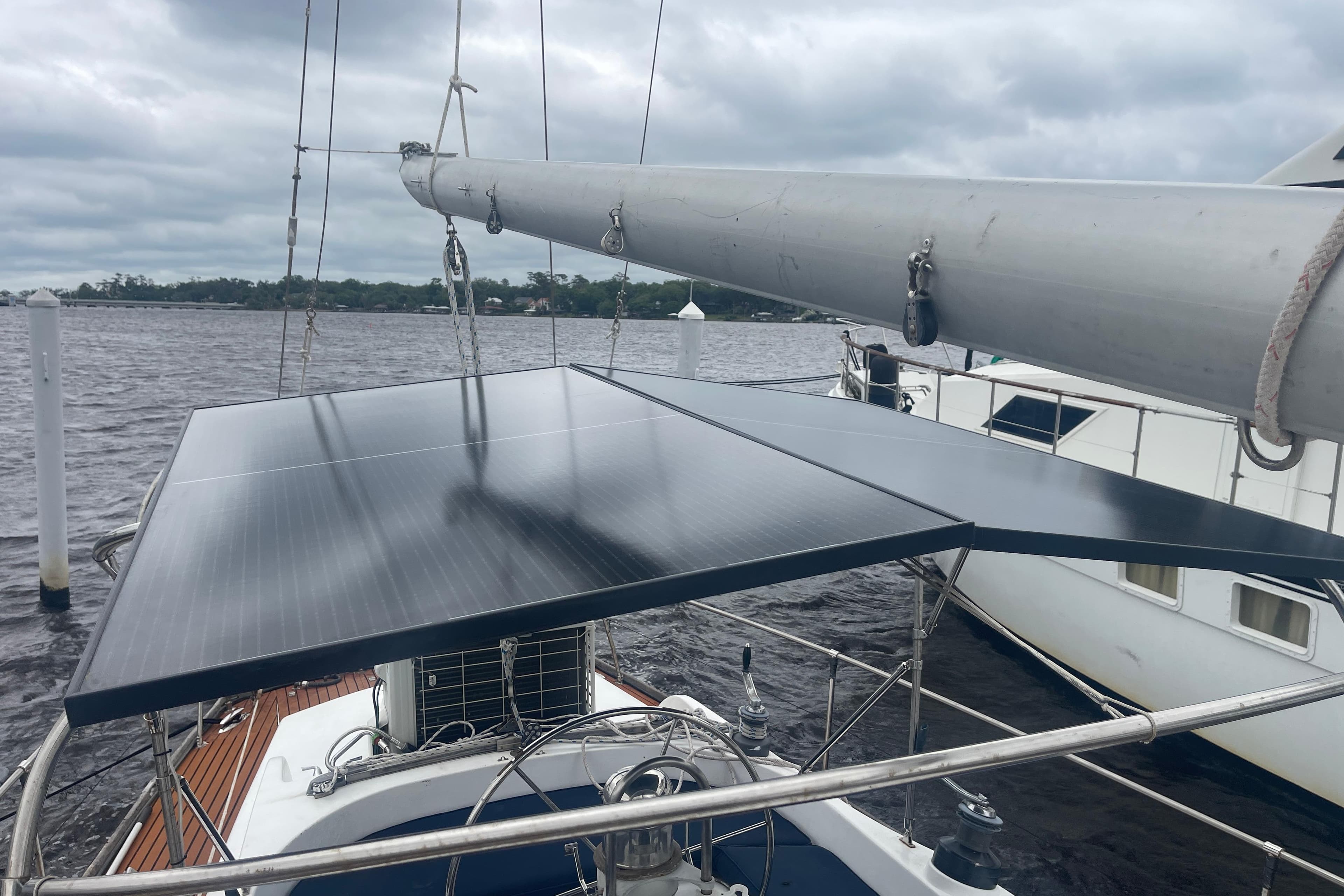 Sailboat with solar panels on deck, TA Chaio CT47, 1984 model, docked on a cloudy day.