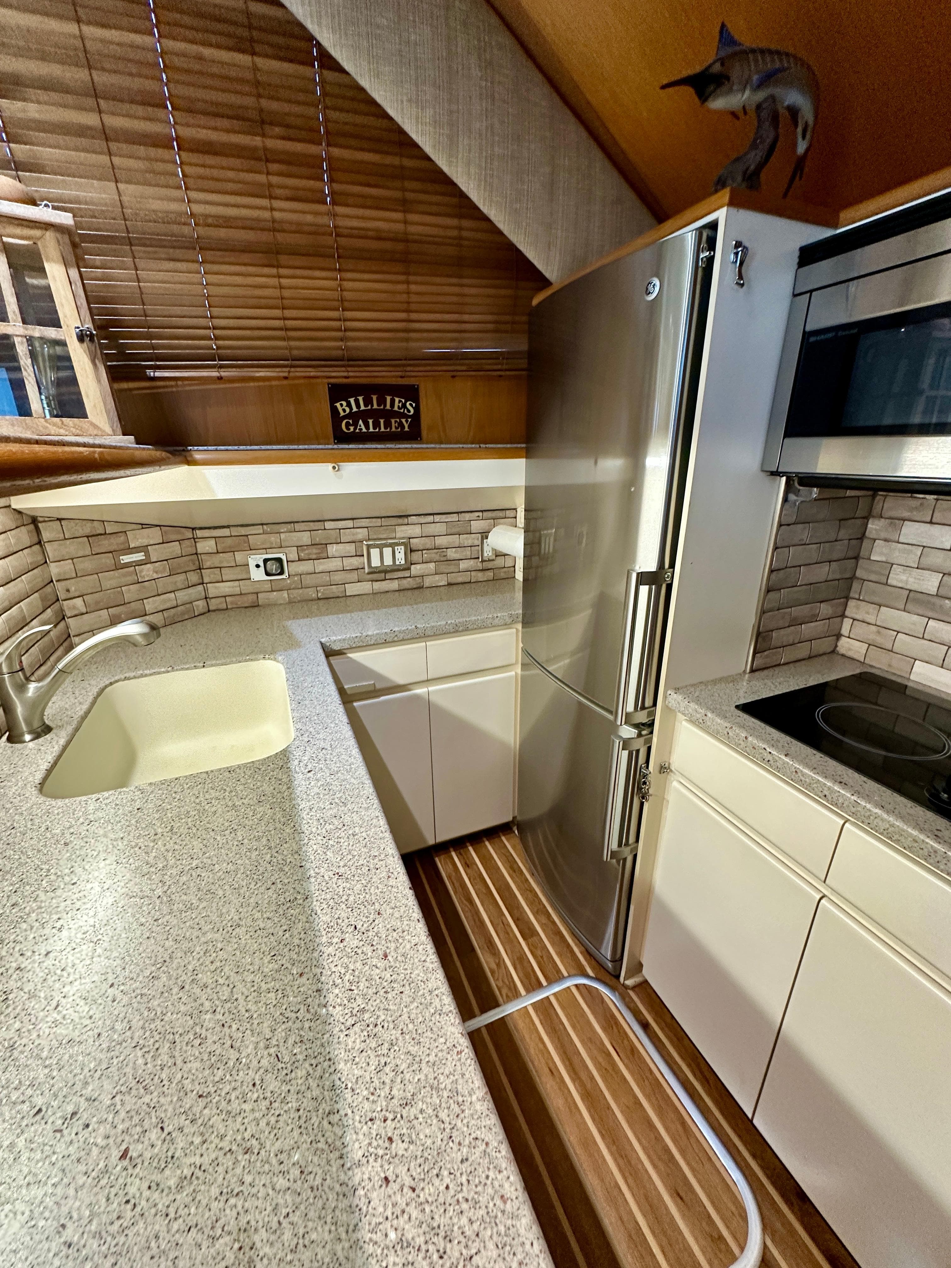 1994 Hatteras 46 Convertible yacht kitchen with modern appliances and wood accents.